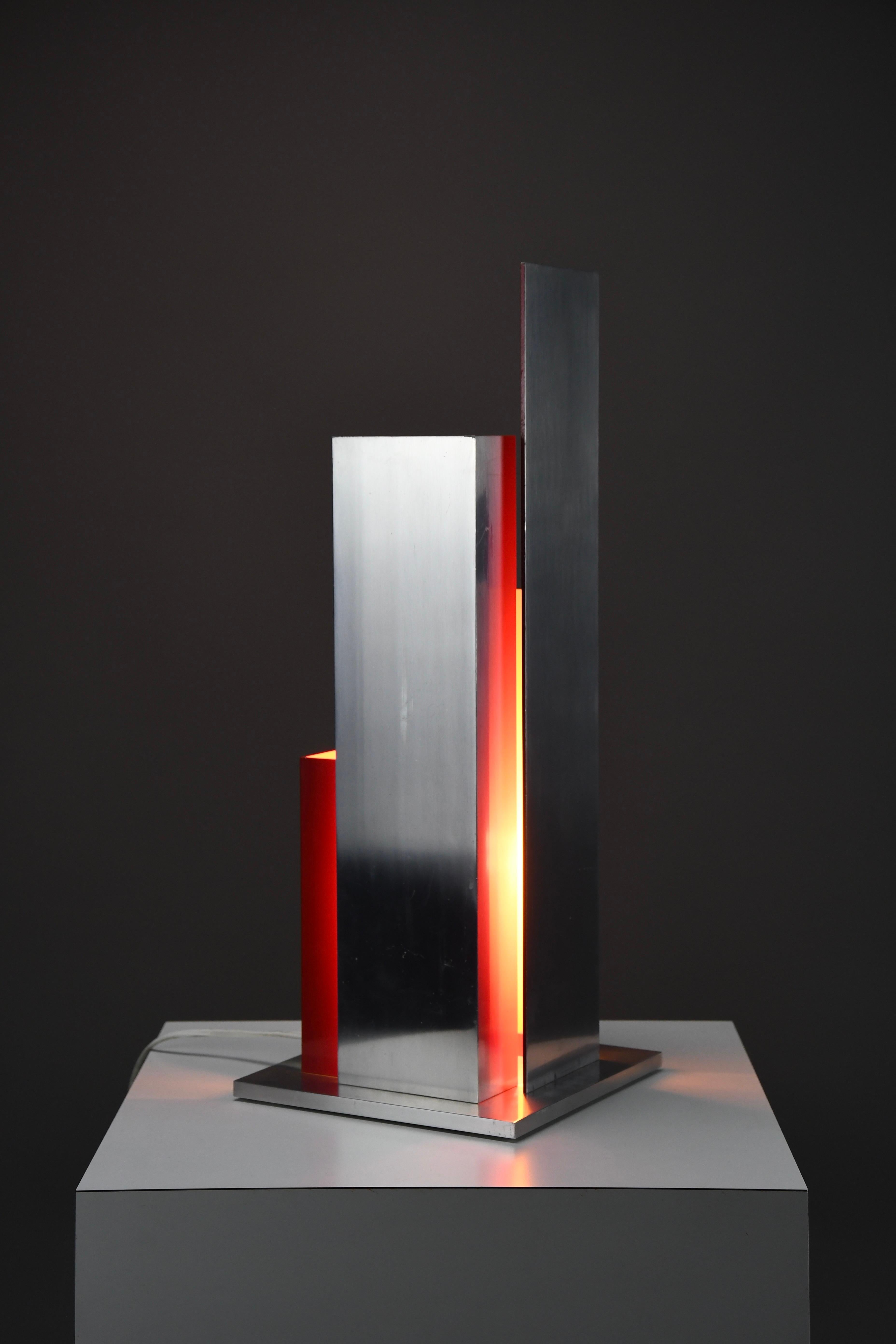 Entrez dans l'âge d'or du design italien avec cette étonnante lampe de table sculpturale en aluminium, dans le style de l'insaisissable et très recherchée New Lamp, Rome. Véritable pièce de collection, cette lampe n'est pas seulement un éclairage,