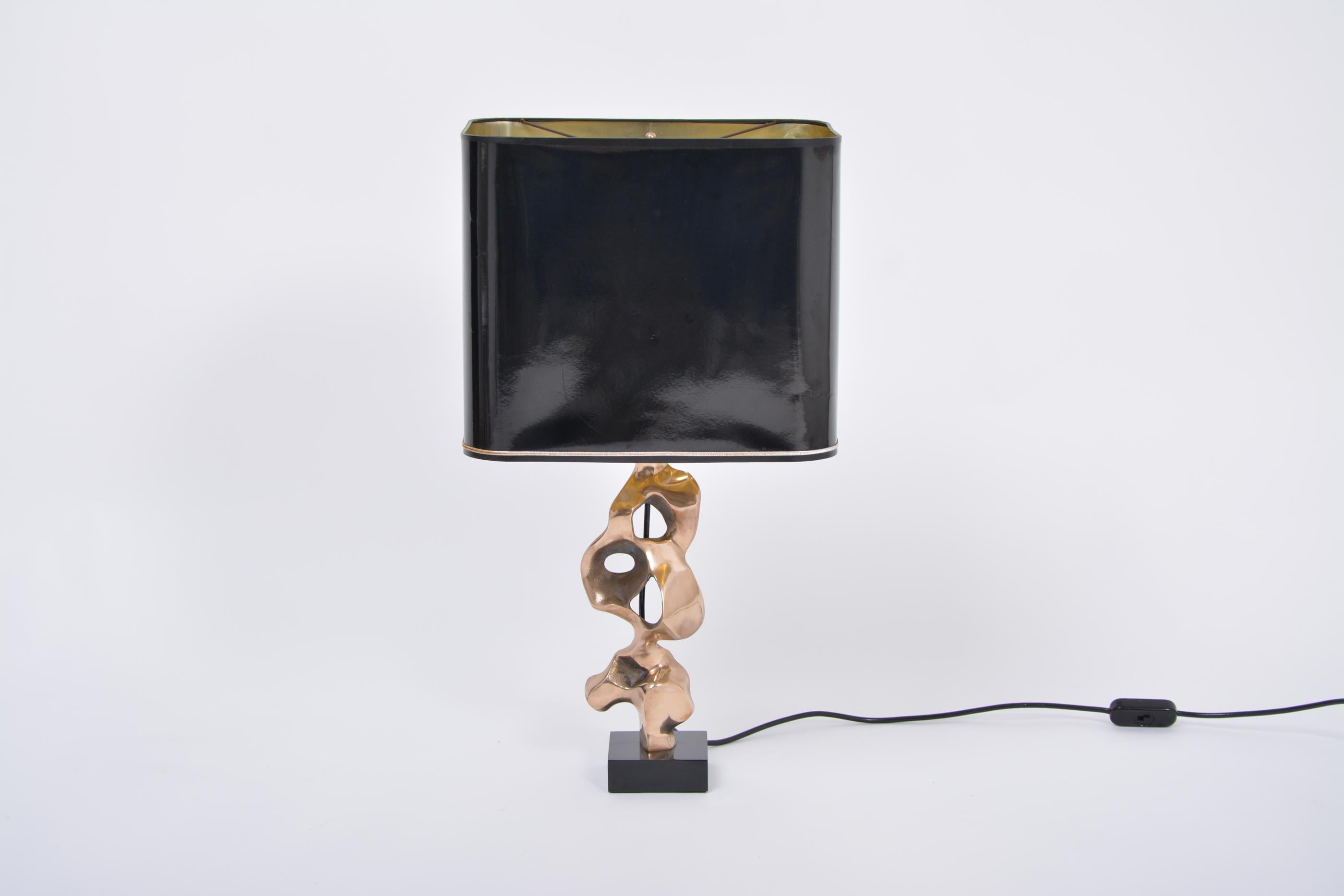 Amazing sculptural table lamp designed and manufactured by artists and sculptor Michel Jaubert in France in the 1970s. This hand sculpted lamp is more a piece of art that gives light as well. Solid bronze sculptural foot with black lacquered wooden