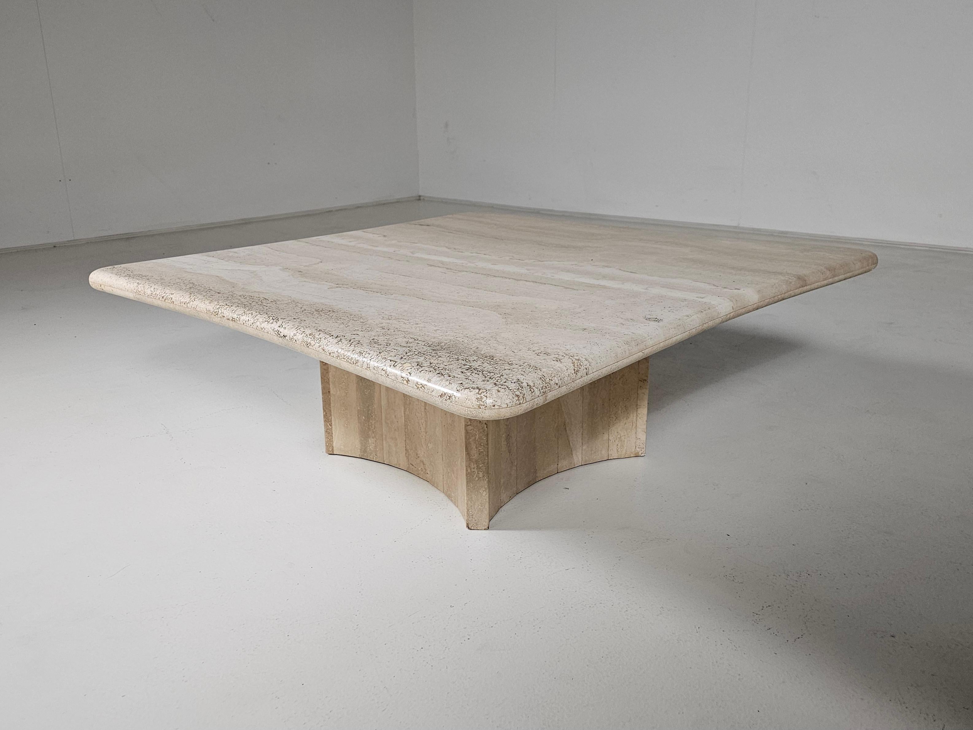 Une table basse vintage remarquable, fabriquée en Italie dans les années 1970. 

Fabriquée en travertin naturel, cette pièce présente un magnifique plateau aux bords doucement arrondis et à la forme élégante et organiquement incurvée. La table n'est