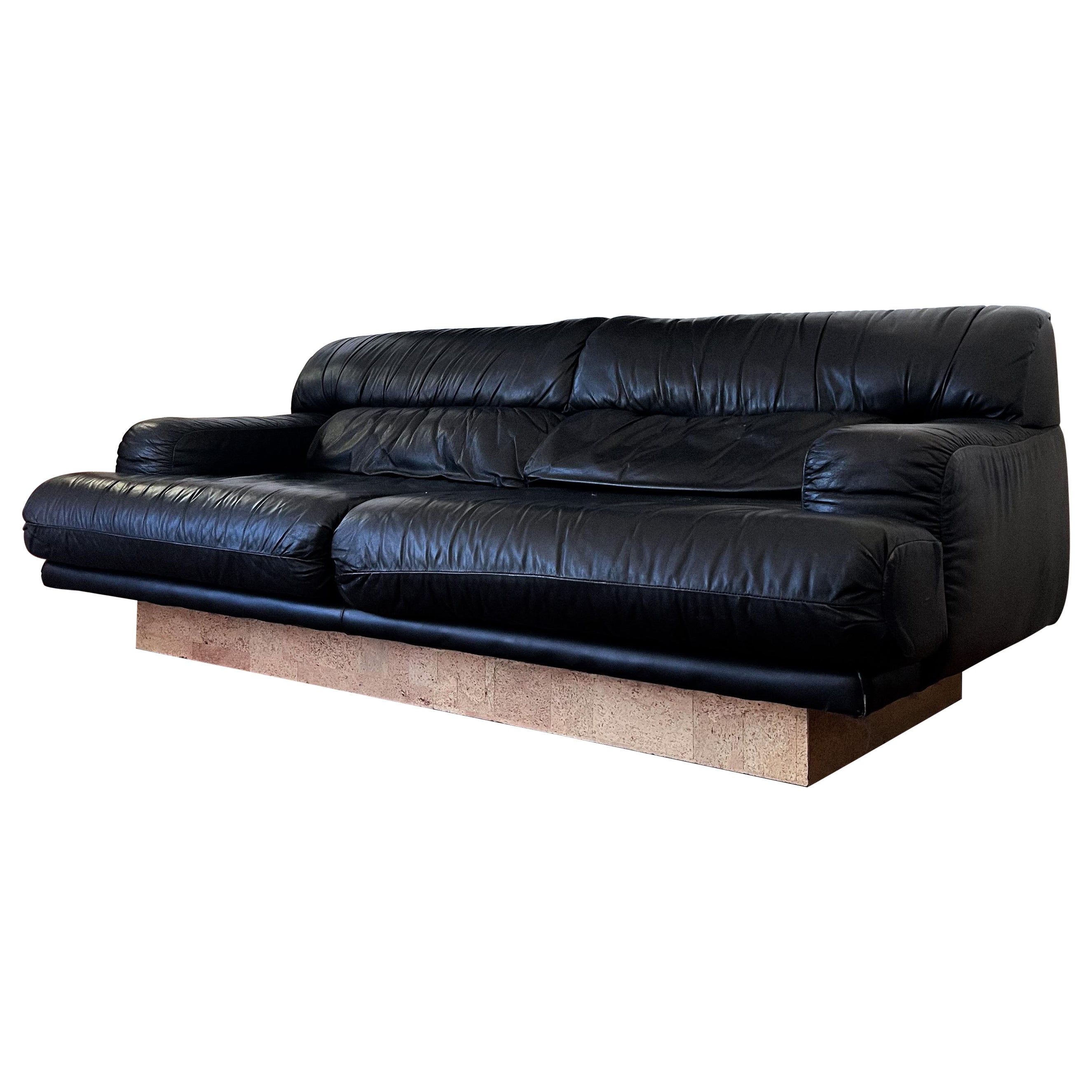 Canapé sculptural en cuir noir des années 1980 sur socle en liège, style De Sede en vente