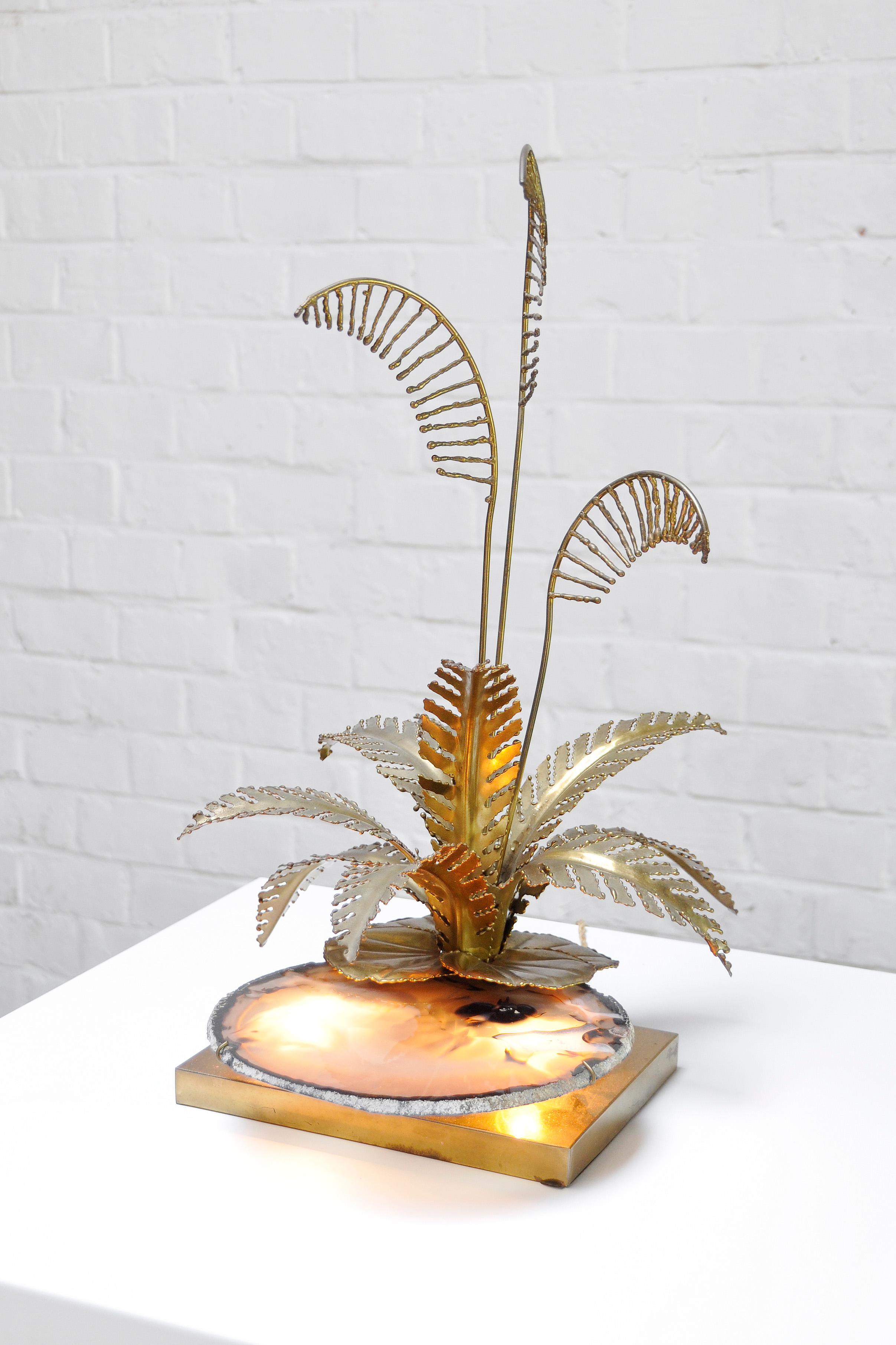 An unusual and impressive sculptural table lamp made by Henri Fernandez in his workshop in the 1970s. The lamp features the organic forms of stalks and leaves made out of warm gilded brass. The centrepiece of this lamp is the flat agate stone which