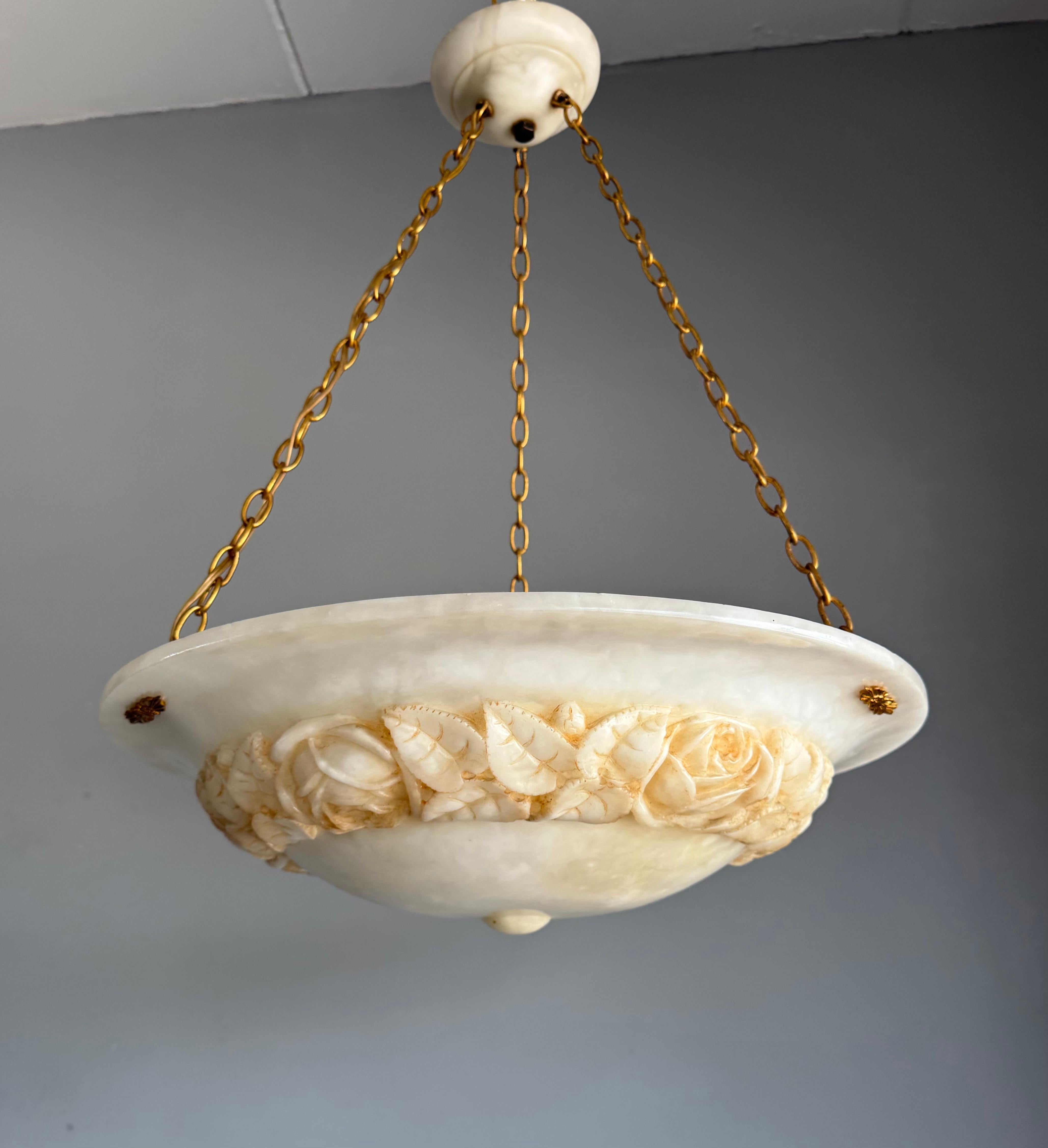 Raro lampadario a tre luci in alabastro Art Decor con rose e foglie in rilievo e decorazioni uniche in bronzo dorato.

Straordinario e raro apparecchio di illuminazione del periodo Art Déco, questa lampada a sospensione in alabastro intagliato a