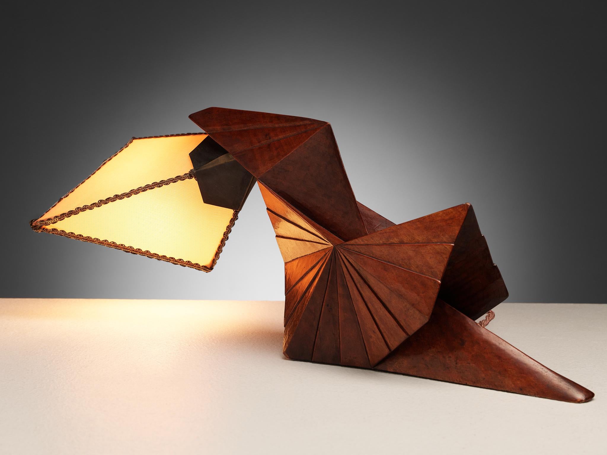 Table or desk lamp, cloth, pear wood, the Netherlands, circa 1925

Exquisite and dynamic wooden desk lamp of the Amsterdam School period. The lamp features a sculptural and hand carved wooden base that seems to resemble a bird. The shade is made of