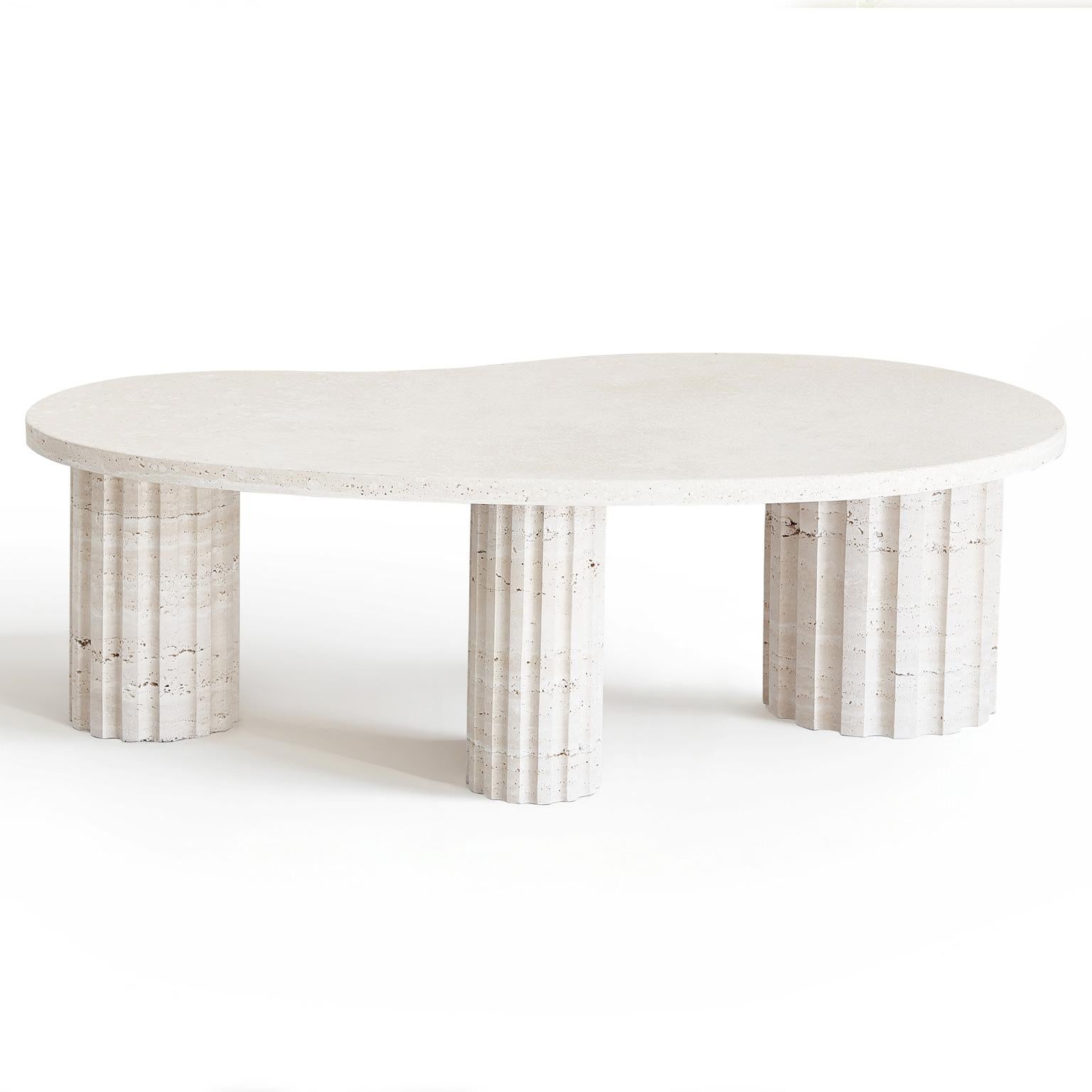 This table, crafted from travertine marble, features an organically shaped top supported by three Roman columns, also made of travertine stone. The design is a unique fusion of brutalism and classical organic forms, creating a striking piece that