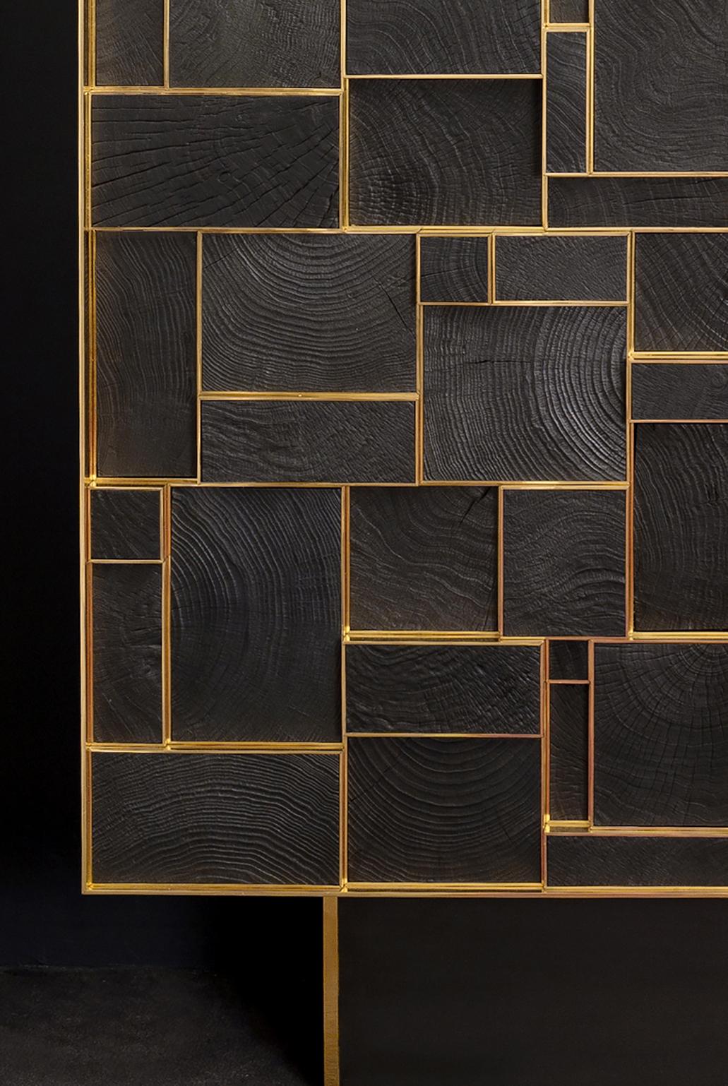 Ce meuble d'étourdissement est fabriqué à la main par Franck Chartrain, un célèbre artiste-designer français.

Le bronze poli encadre plusieurs sections de bois carbonisé. 
Des cubes émergent des portes à des hauteurs différentes.
Les poignées sont