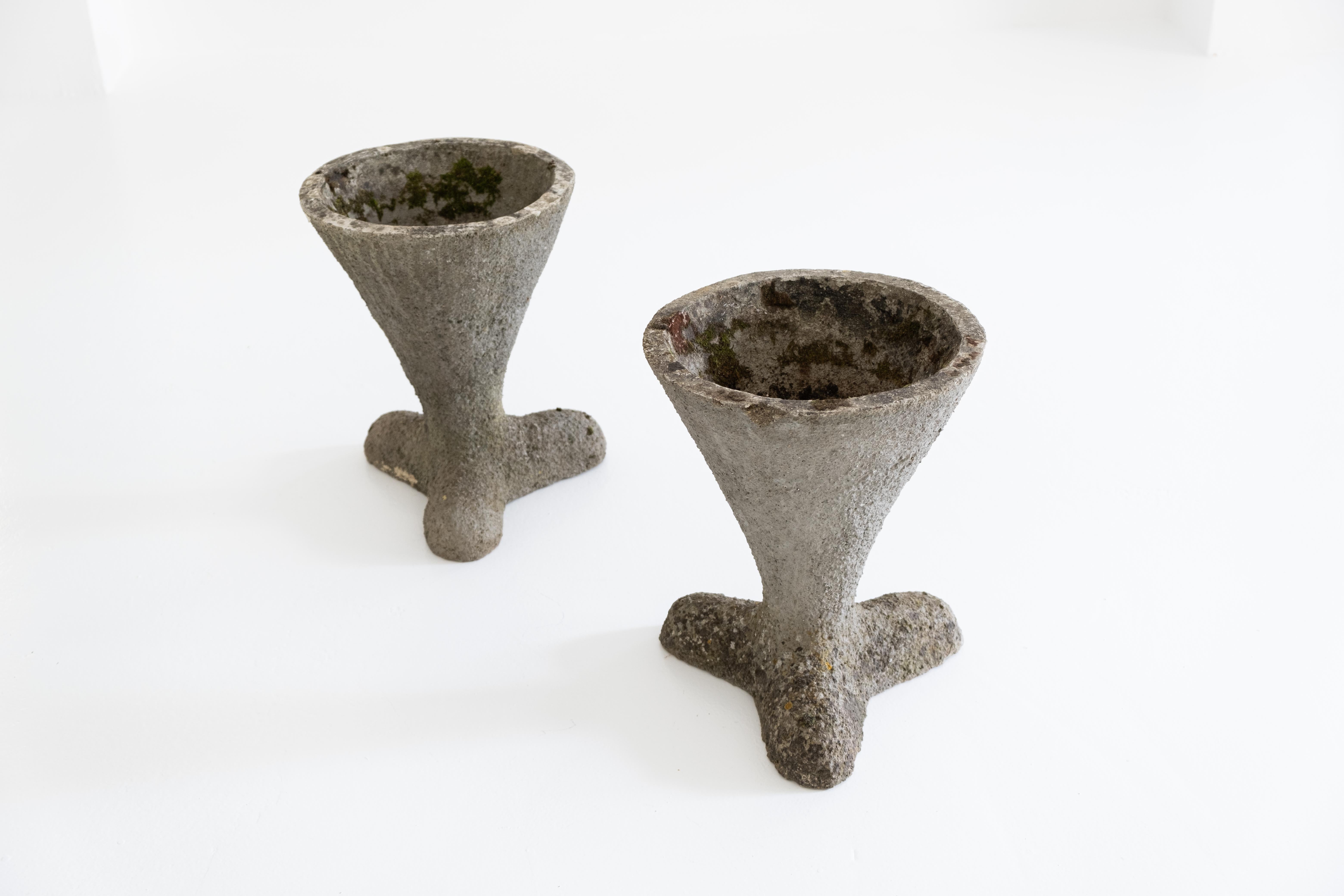 A small, sculptural and very decorative pair of concrete planters. The shape resembles an inverted cone supported by a chubby propeller foot. probably from the 1970s. Found it on the french atlantic coast, very good condition with wonderful