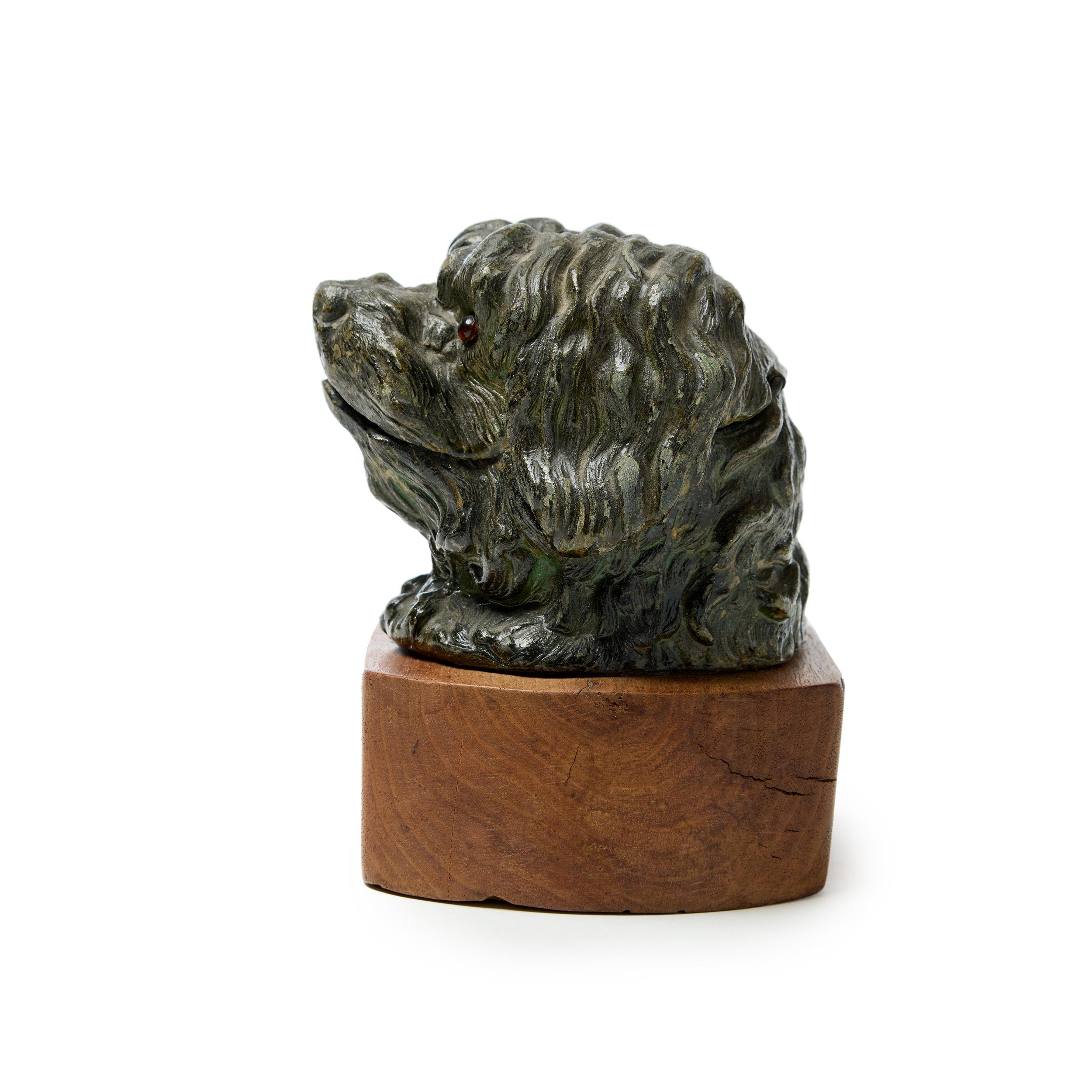 Antique cast metal sculpture of a Maltese Terrier. The hinged cover reveals a glass lift-out inkwell.