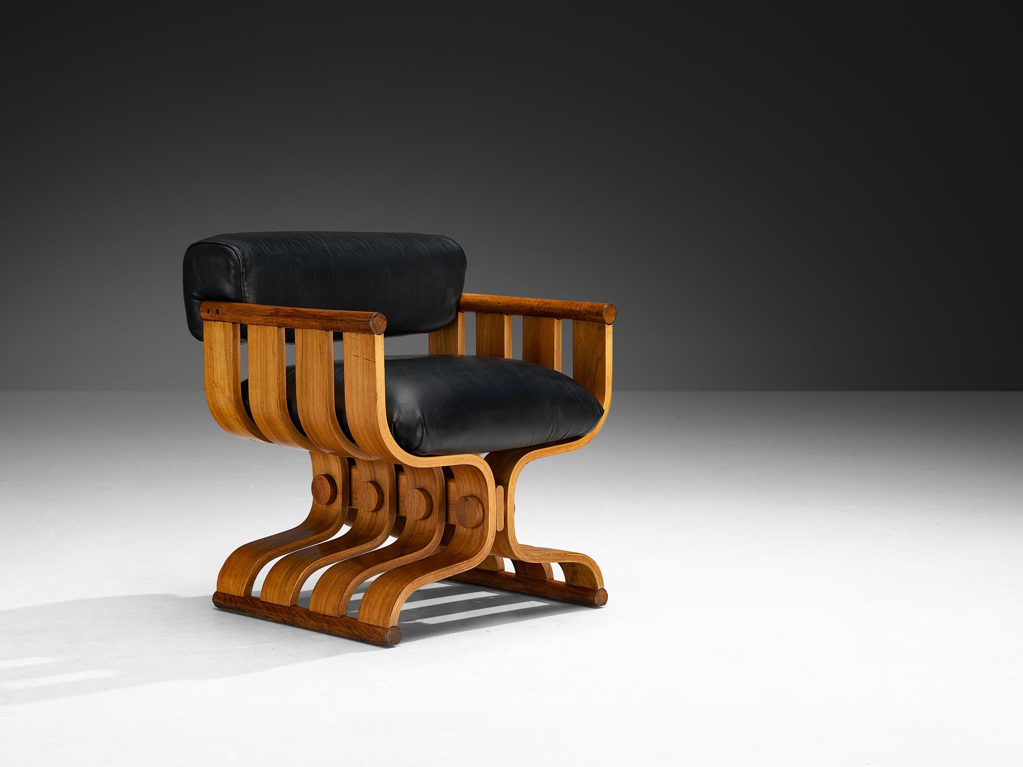 Armchair, walnut, Europe, 1970s

This beautiful lounge chair, influenced by the artistic sensibilities of the Art Deco movement with a post-modern twist, is distinguished by its stately grandeur and curvilinear forms. The design is highly