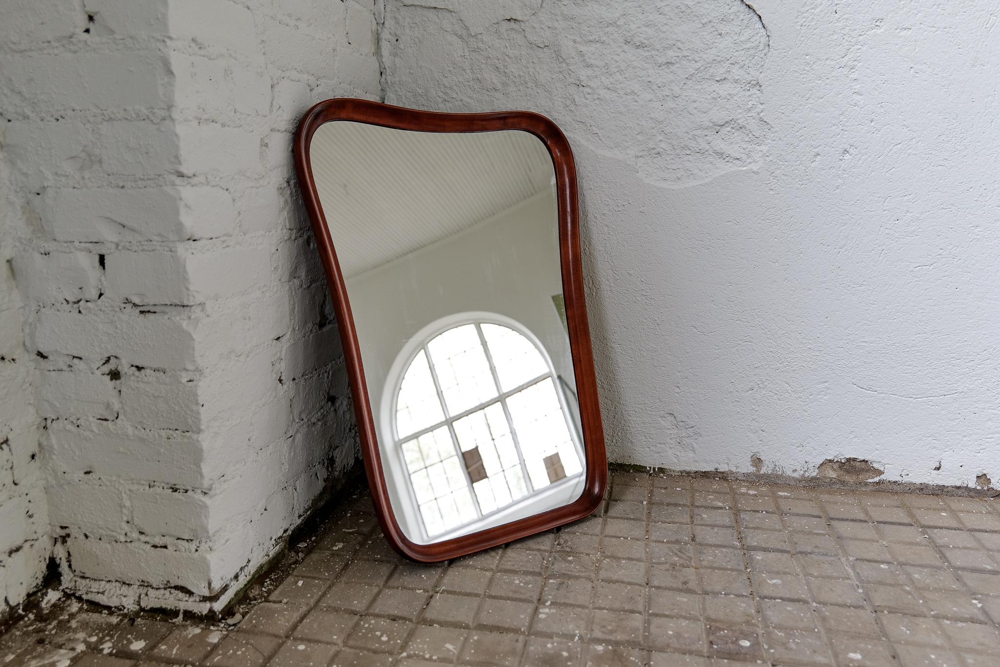 Sculptural wall mirror in mahogany, produced in Sweden during the 1940s.
The mirror is made in lacquered mahogany. The mirror itself is made with curvy sculptural lines, with high quality.

Good vintage condition, small scratches, and the glass