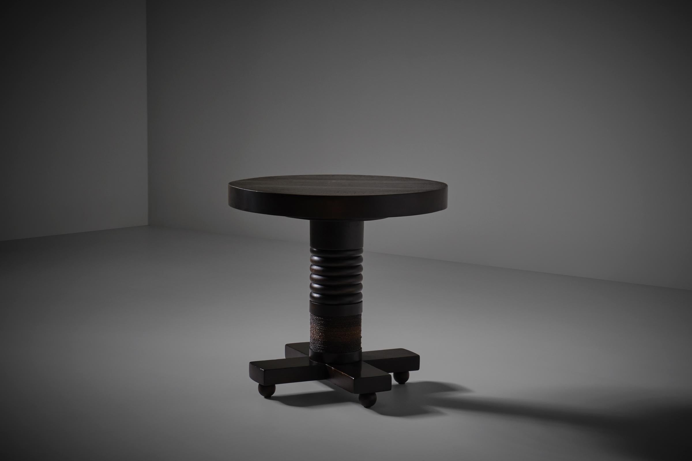 Sculptural Art Deco side table, France 1920s. A beautifully by hand chiseled round dark stained Alder wooden table top rests on a nice detailed base constructed out of a stacked ring shaped center column with elegant sisal rope detailing on a cross