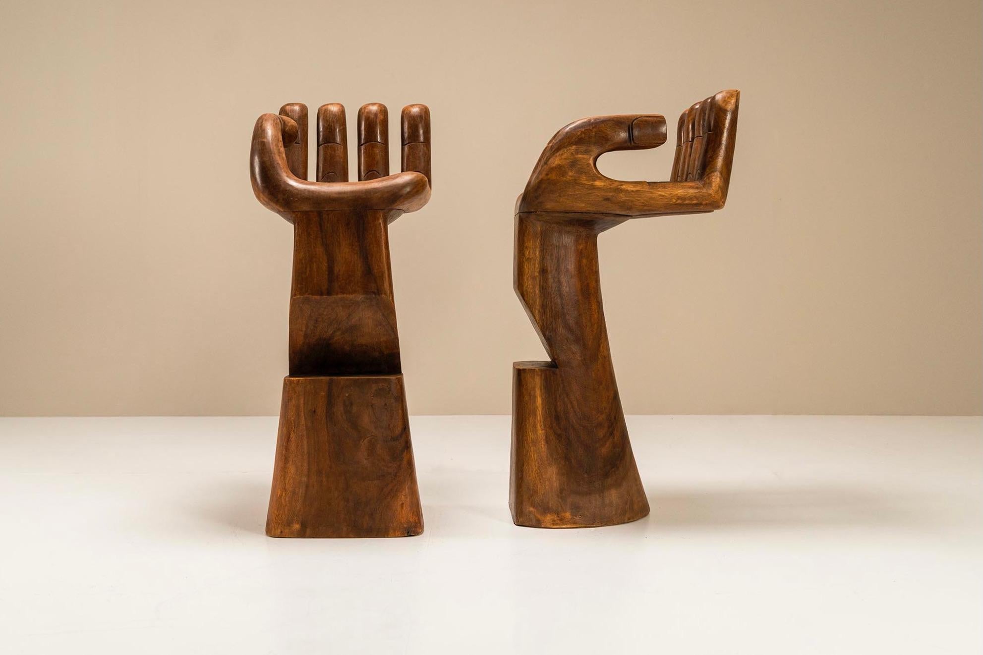 These two wooden sculptural bar stools are handmade in the 1970s and have a unique appearance. They consist of two pieces of wood, the base, and the seat. A sturdy base is provided with a notch halfway through to rest your feet on it. The foot flows