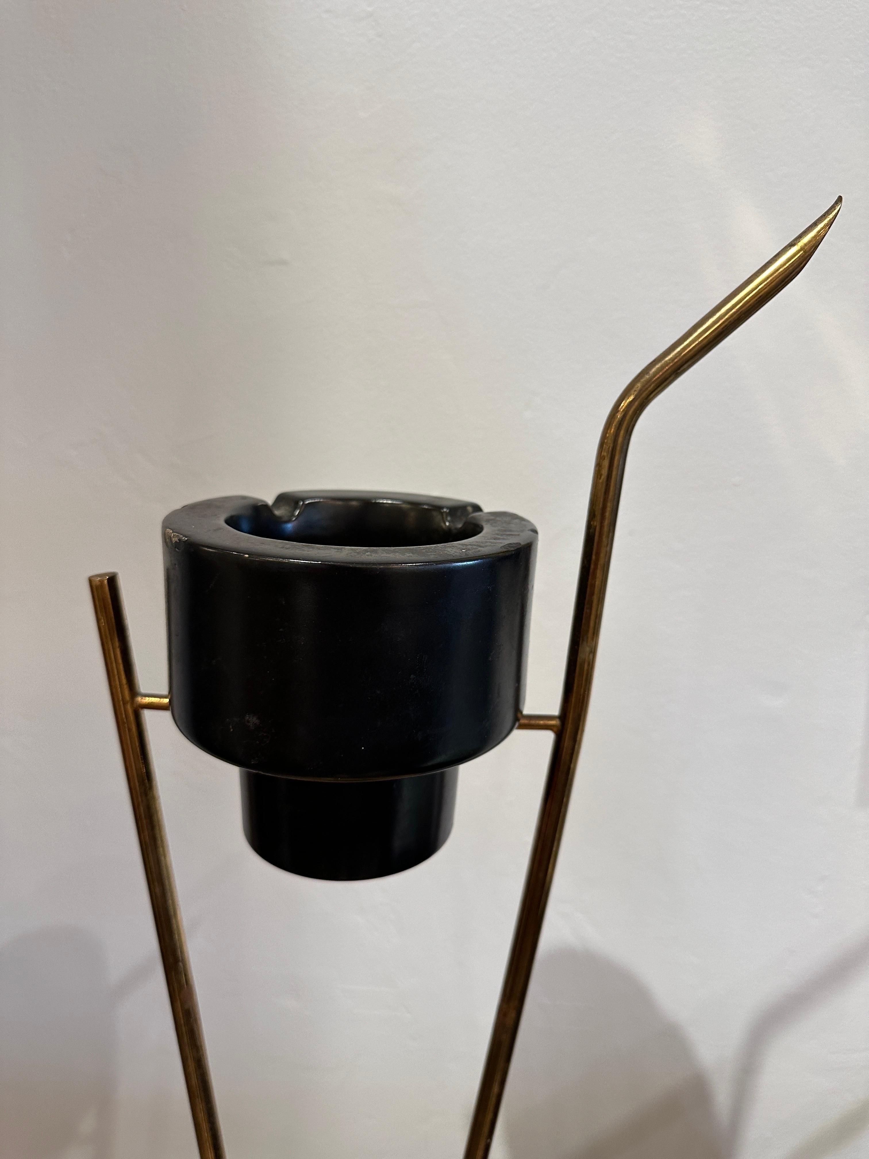 This French ashtray stand with brass body and metal base, has an original black ceramic bowl with a few flea bite chips.  