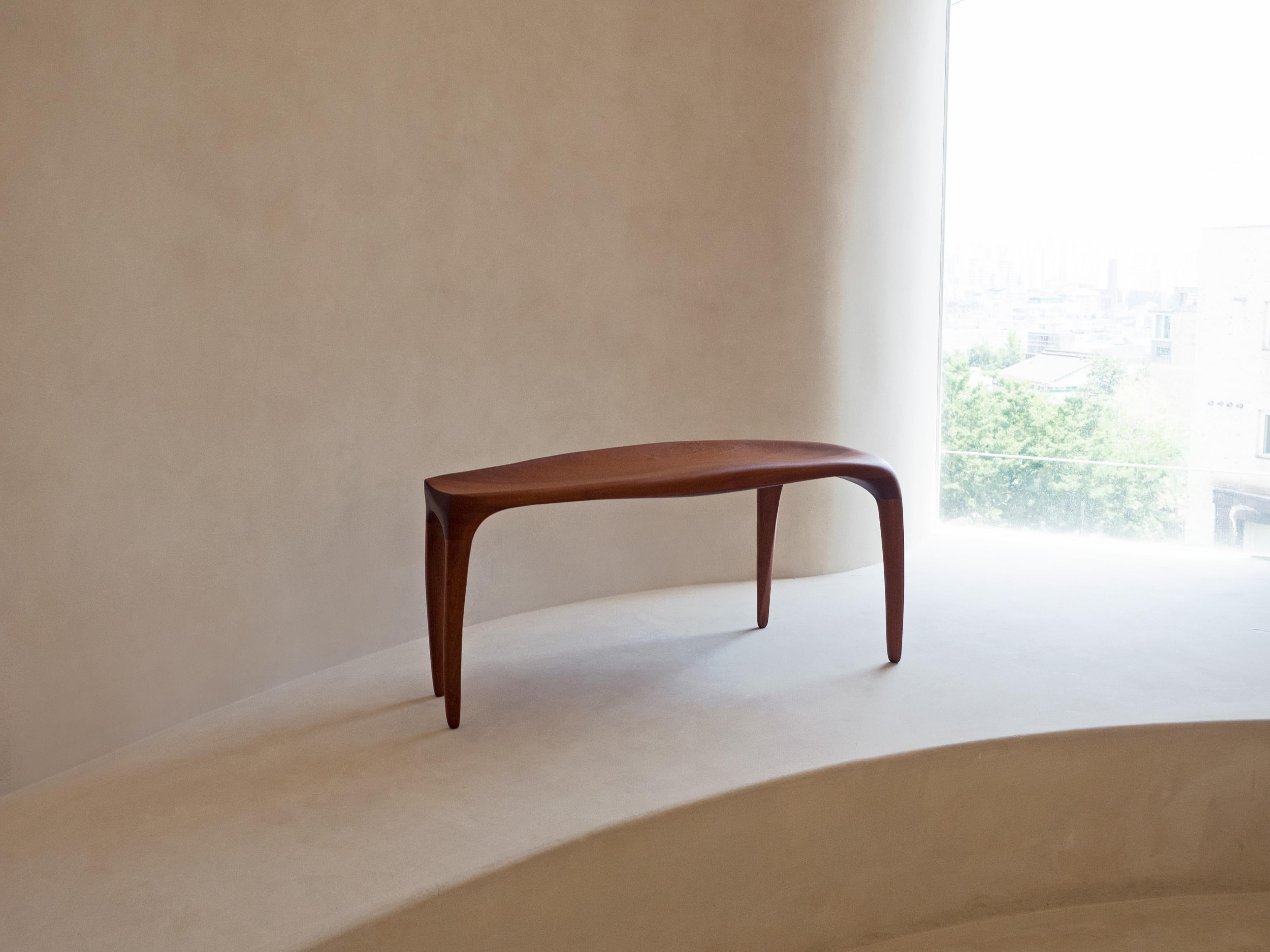 'Motion Bench' by Soo Joo is a sculptural wooden bench in Organic Modernism style. The artist creatively reimagines the essence of traditional Korean aesthetics into a modern minimal context. 

Motion bench is carved out of stack-laminated Sapele