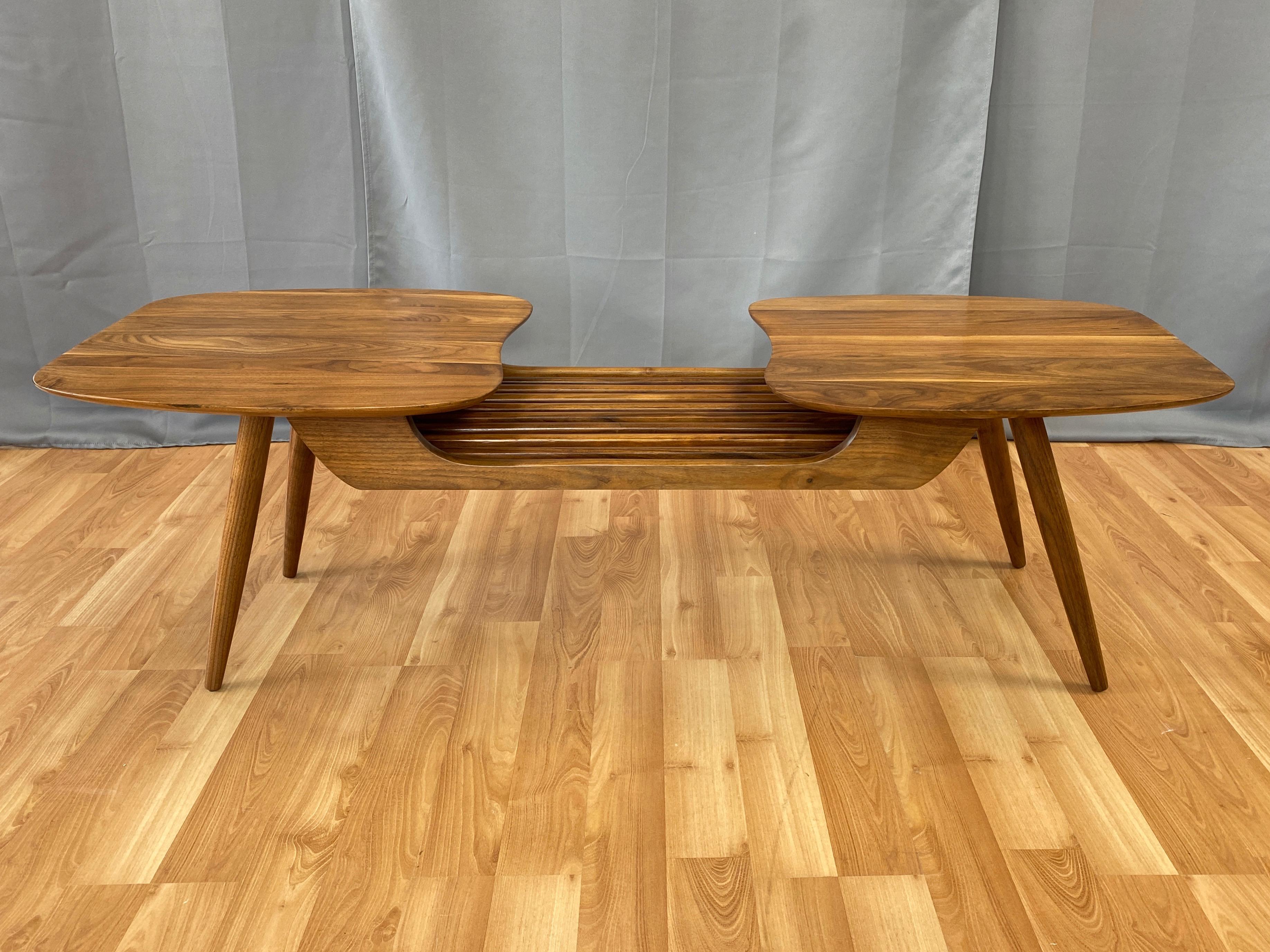 A strikingly sculptural and possibly unique 1960s mid-century modern solid walnut coffee table with bi-level biomorphic and slat top.

Pair of lily pad-like surfaces float above a central slat section and are connected by sleigh runner-shaped sides.