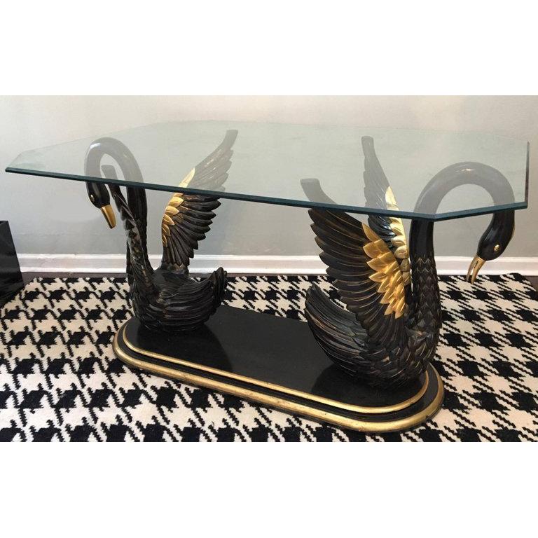 Hollywood Regency style at it's best! Two carved black swans with gold gilt detailing atop a platform make up the base of this glass-top dining table. Excellent vintage condition with only very minor abrasions consistent with careful use.

Base