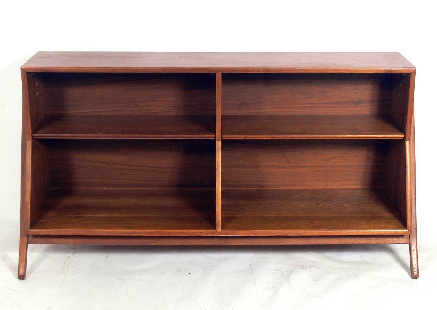 Sculptural bookshelf, designed by Kipp Stewart for Drexel, American, circa 1960s. This piece has a Danish Modern style with elegantly flared legs. It is a versatile size and would work as a bookshelf or bookcase, credenza, vitrine or bar.
