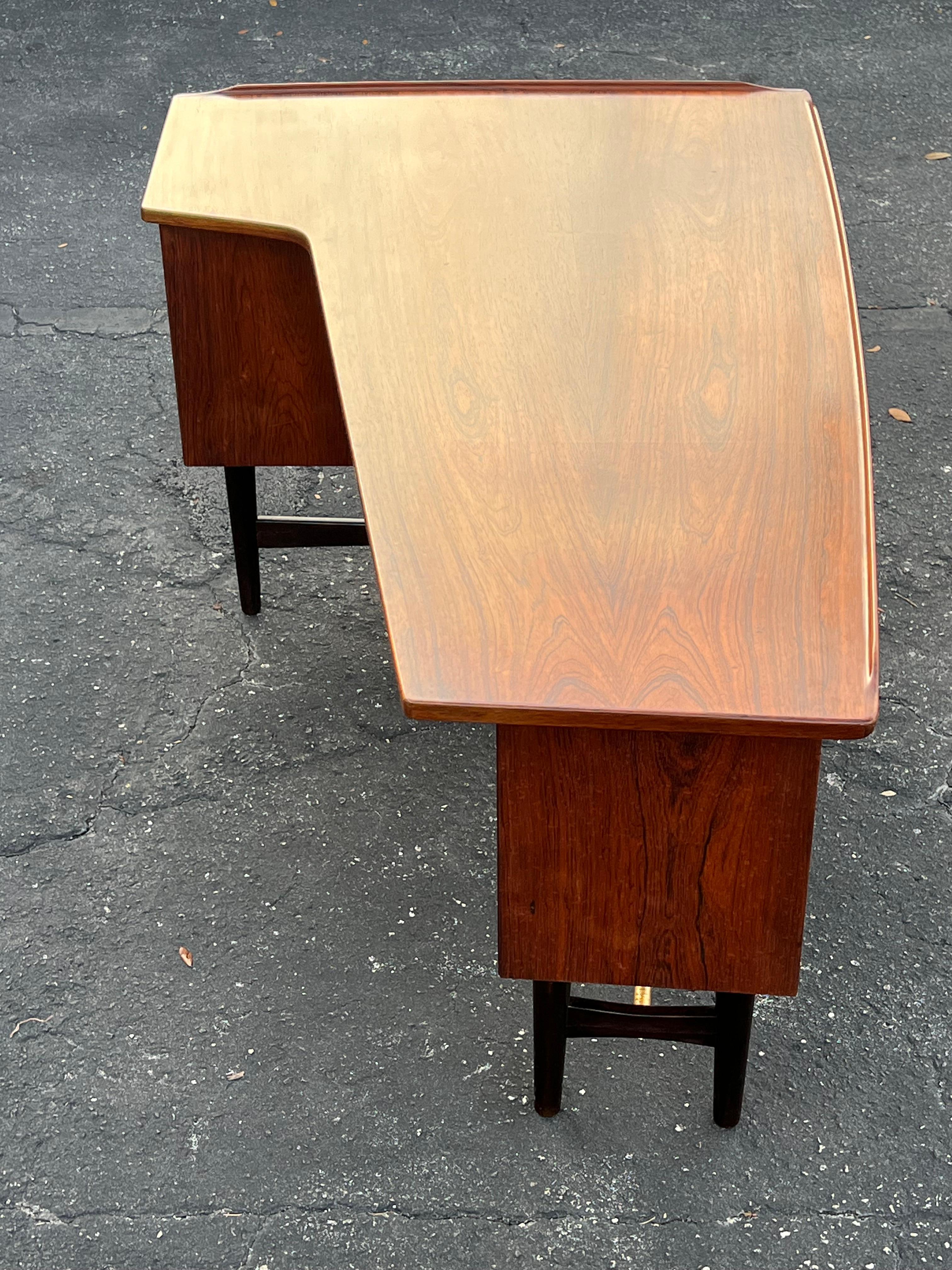 Beautiful  ‘Boomerang’ desk designed by Peter Løvig Nielsen and produced by Løvig in Denmark, 1960s. A highly refined design with great details such as the shape of the top with sculpted, raised edges. This desk is made of nicely grained Brazilian