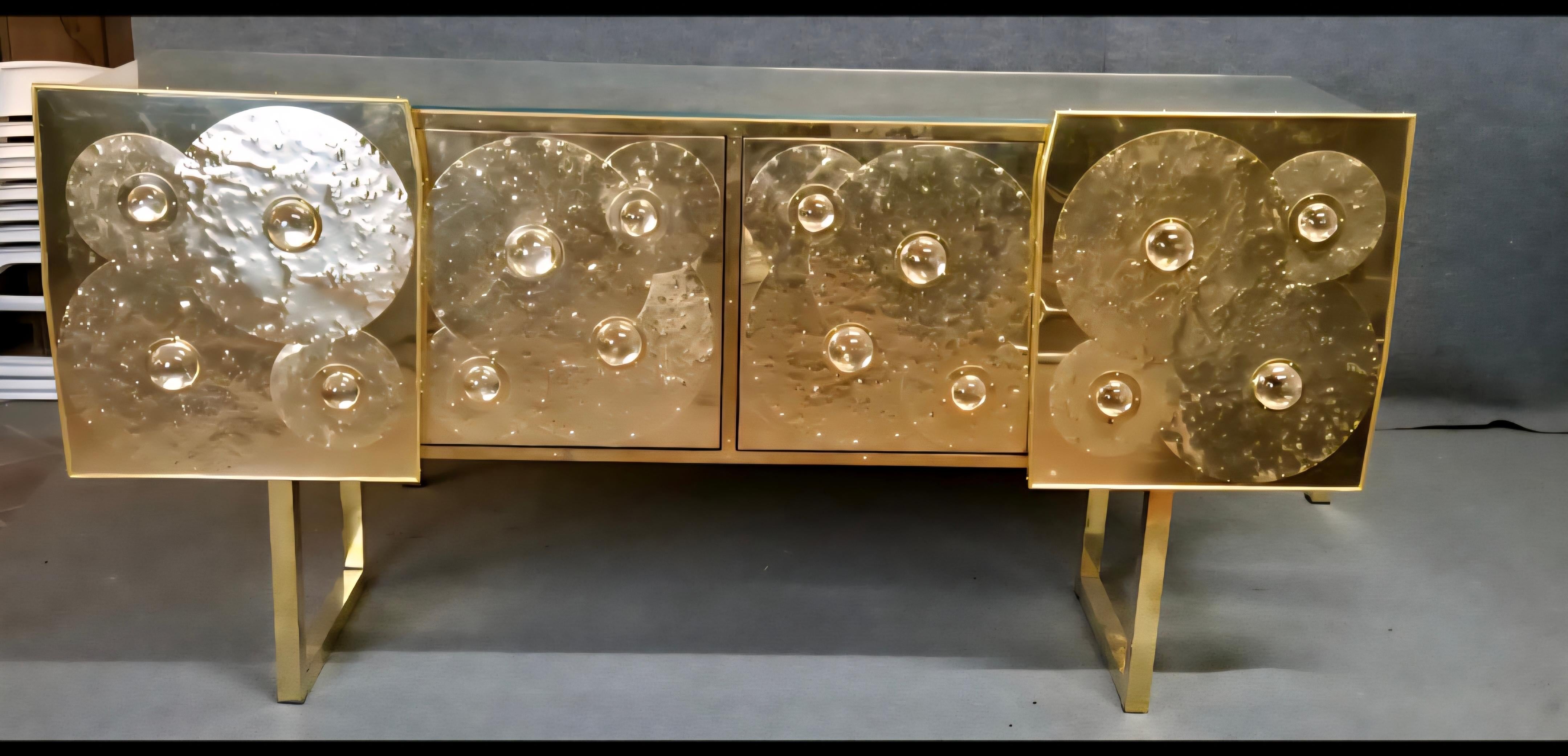Conçu et fabriqué à la main en Italie par Justfurnituress, ce buffet sculptural est une pièce d'exception qui allie design de collection et savoir-faire artisanal.

L'ensemble de la façade est revêtu de laiton poli et martelé à la main, composé