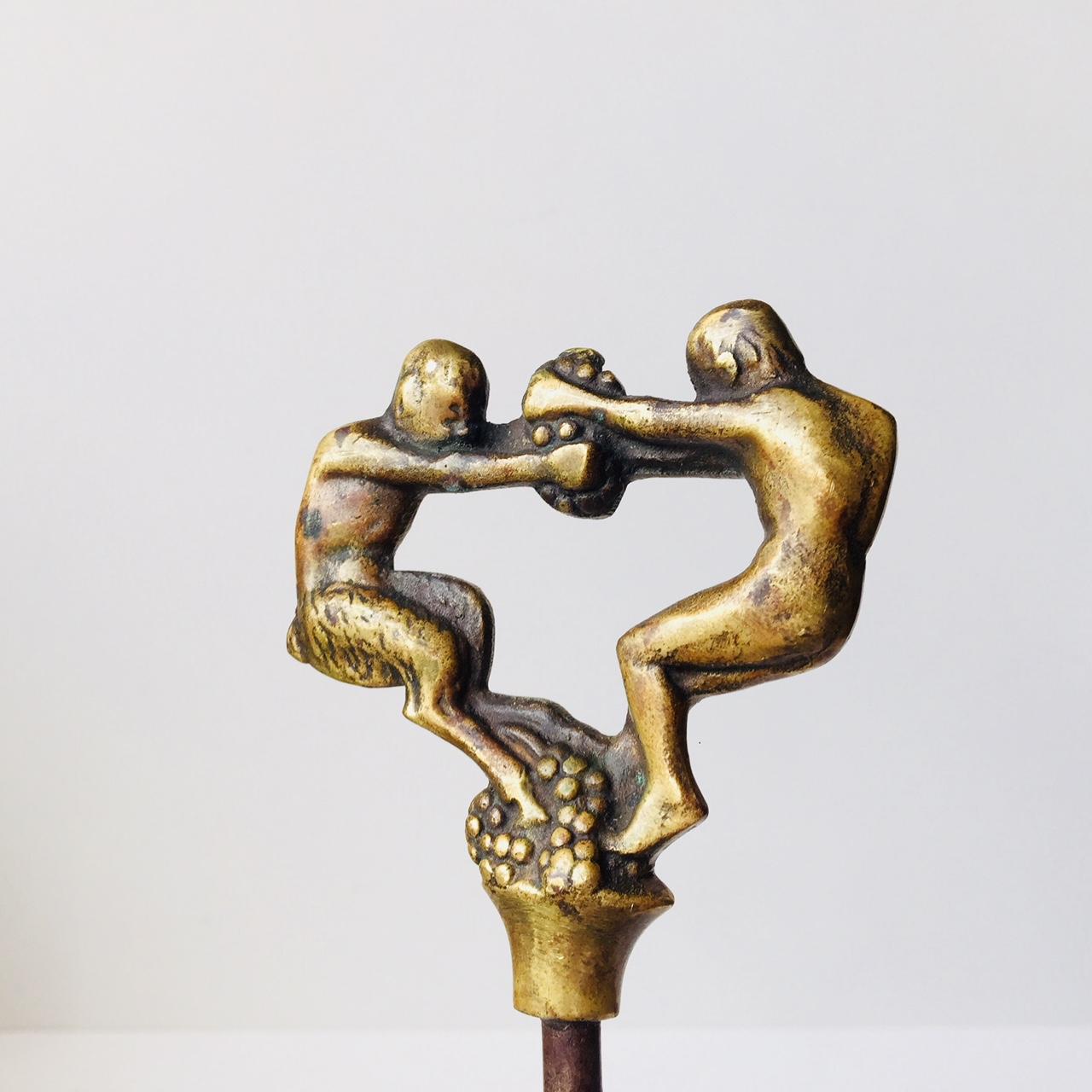 This vintage corkscrew in brass and steel was designed by Kay Bojesen in the early 1920s and manufactured by E. Dragsted in Copenhagen. The top of the corkscrew depicts a faun fighting a man over grapes.