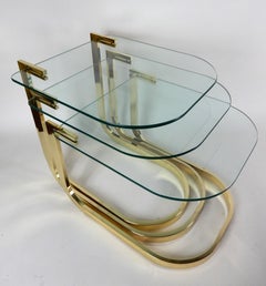 Conjunto escultórico de mesas nido de latón con tableros voladizos de cristal