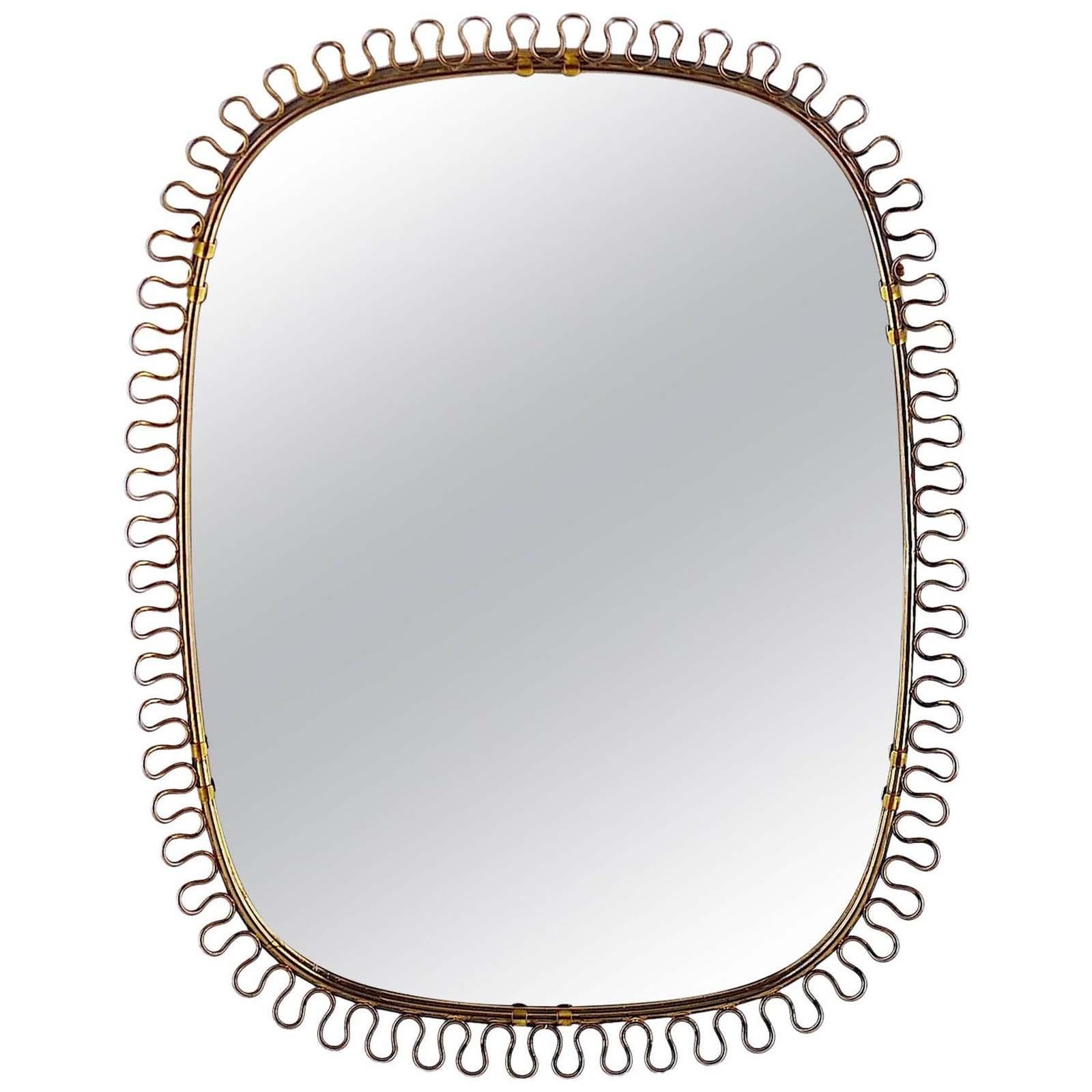 This beautiful brass loop wall mirror was designed in Sweden by Josef Frank for Svenskt Tenn in the 1950s. The brass frame with nice warm vintage patina. The original mirror glass flawless.