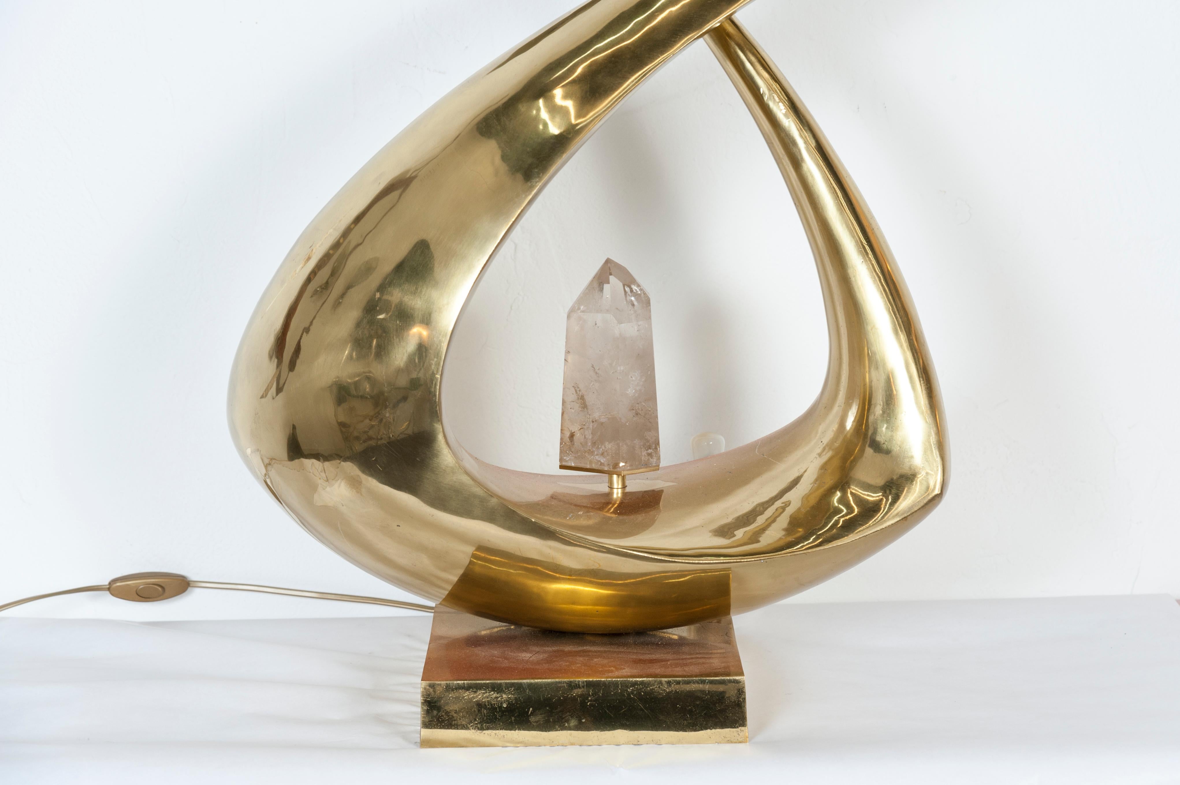 Luminous sculpture more than a lamp, this amazing piece signed by Georges Mathias is a work of art.

A one piece brass sculpture going both ways with a rock crystal in the middle diffusing the light.
Signed.
 