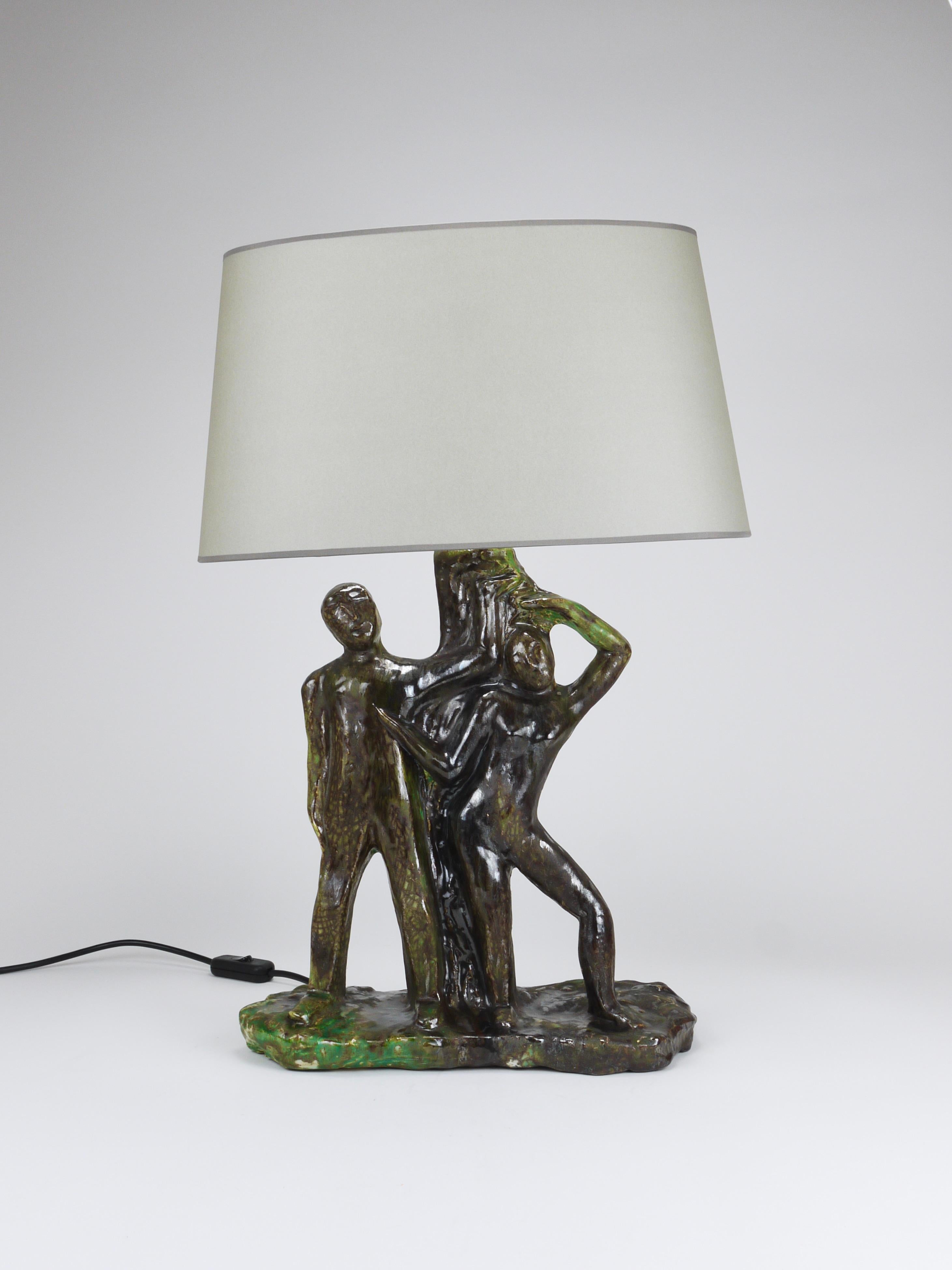 A sculptural Brutalist table or side lamp dating from the 1970s. We sourced this beautiful piece in Italy; it depicts a man and a woman (possibly Adam and Eve) standing beside a tree or column.This is a one-of-a-kind piece: the handcrafted ceramic