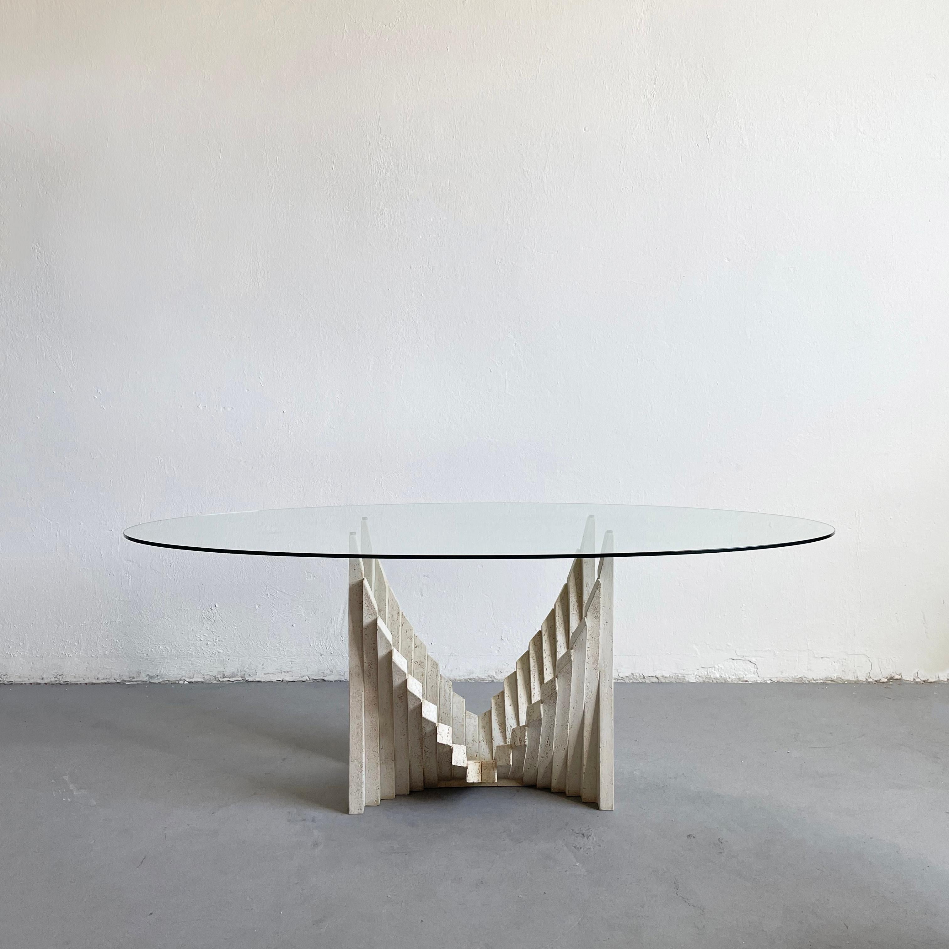 1970s Italian dining table by an unknown maker/designer

The table is very sculptural with a heavy travertine base in a brutalist style

The heavy oval-shaped tabletop is made of clear tempered glass

Suitable for 6 dining chairs

The table is in