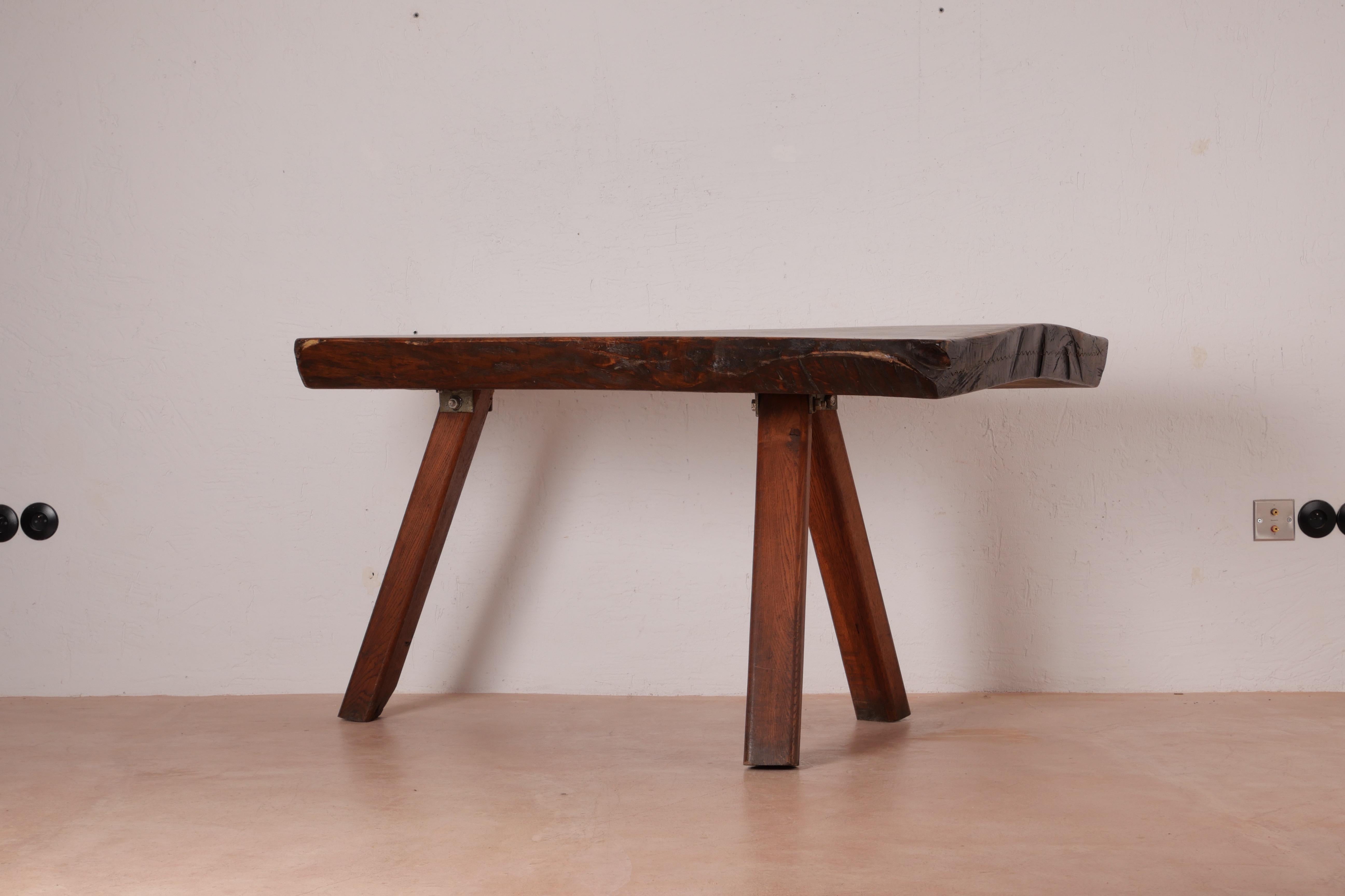 This sculptural Brutalist table has been handmade from solid pine slabs by Mobichalet of Belgium in the 1950s. The parts have been joined in a fashion that feels rudimentary and rustic on purpose, harking back to earlier Alpine craftsmanship –