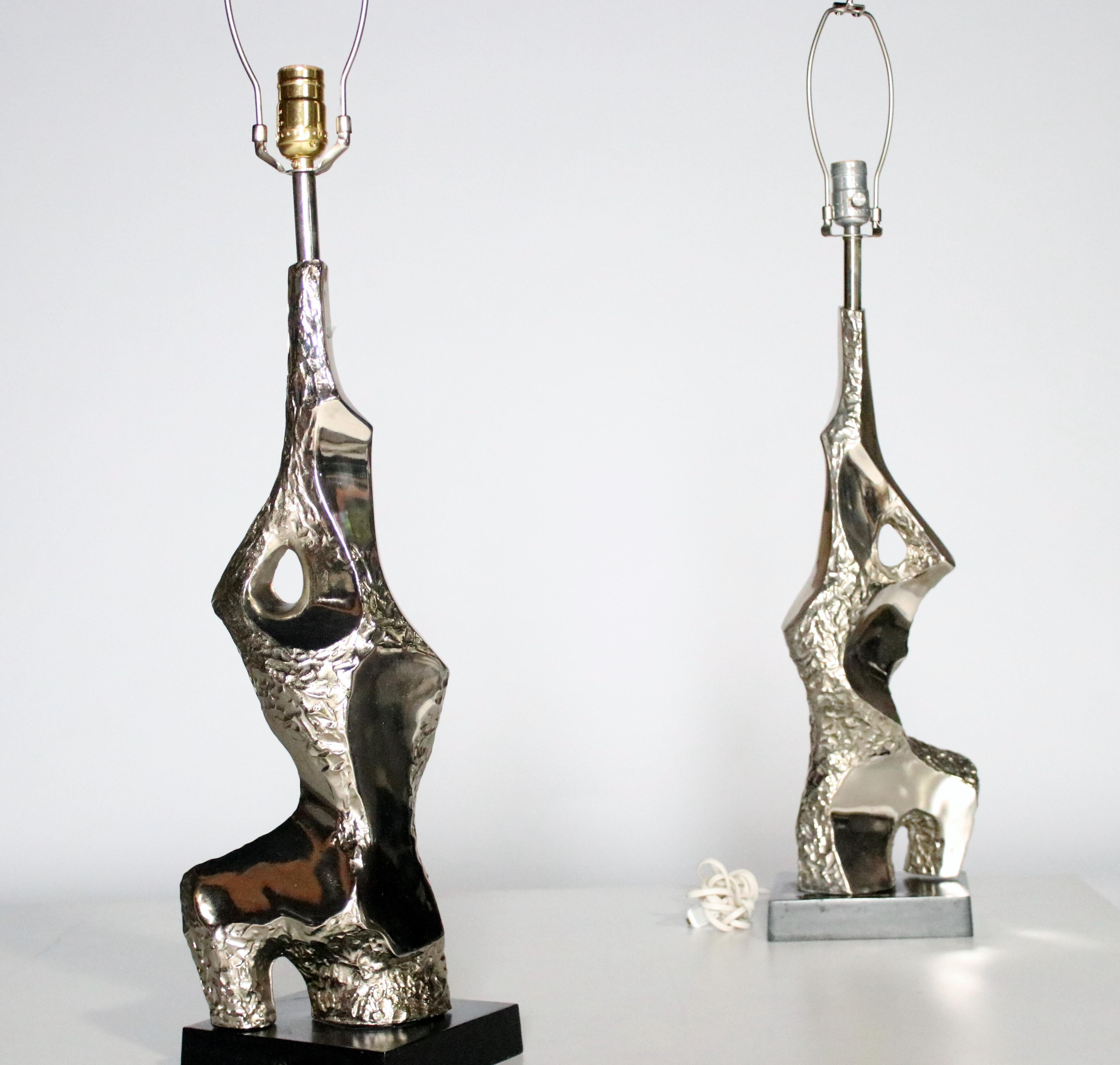 A pair of chrome sculptural Brutalist style lamps designed by Laurel Lamp Co, 1960s. These iconic and often rare Mid-Century Modern lamps are designed in an abstract textured metal on black trapezoid bases. Some parts have been updated with newer