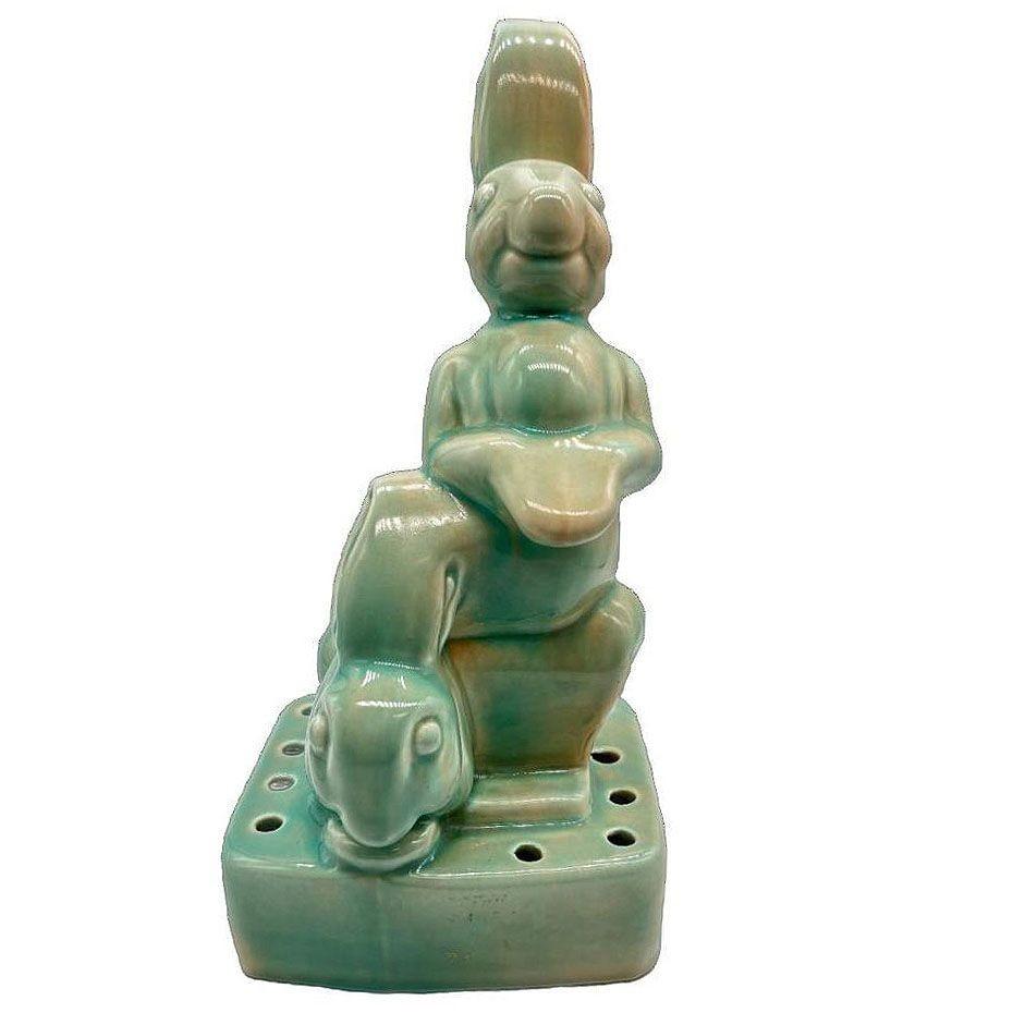 Mide-Century era bunny rabbit flower frog vase by West Coast Pottery with this vintage piece featuring pair of rabbits on top of a pot of land. Crafted with intricate detail, this whimsical creation captures the essence of nature and whimsy. Adorned