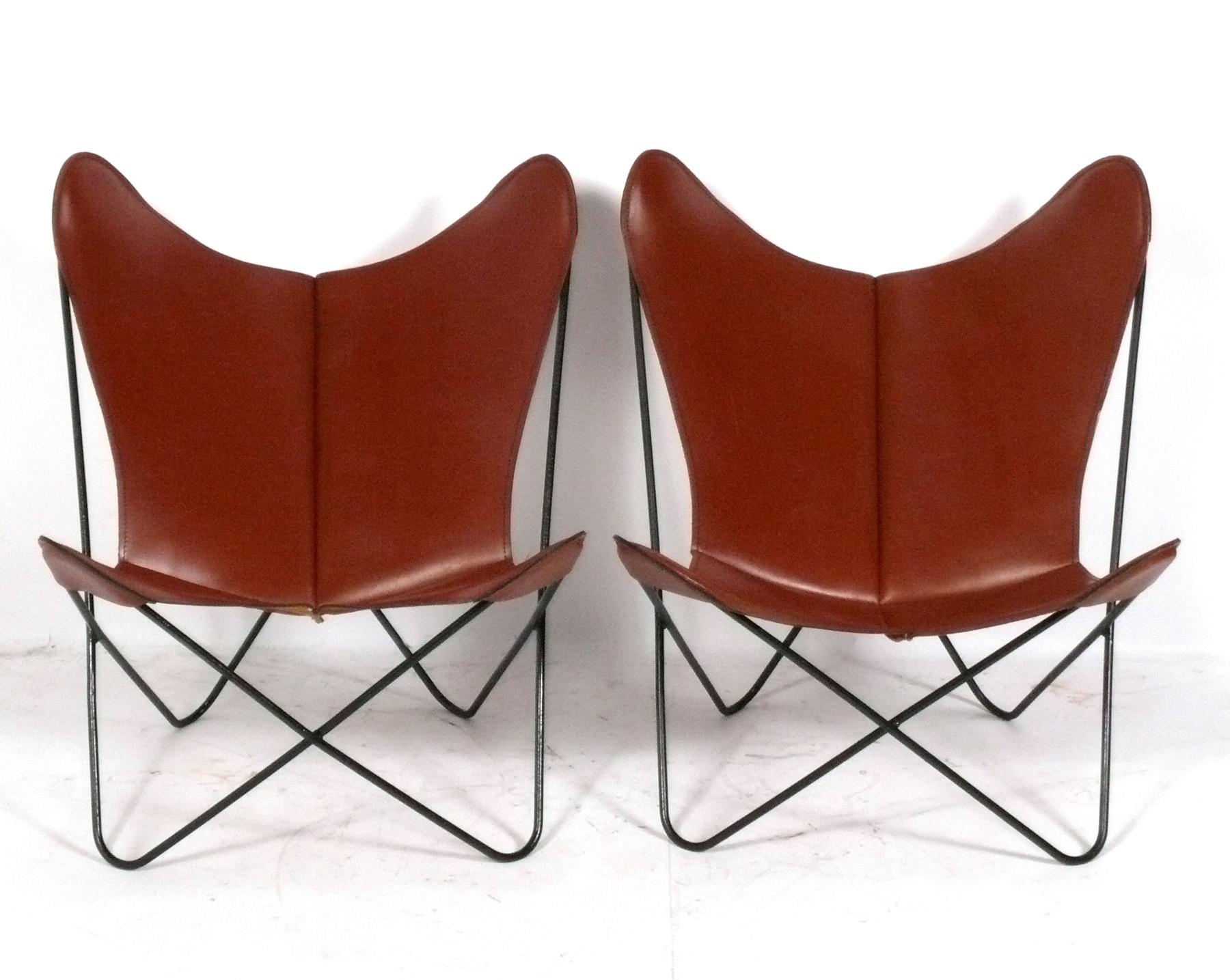 Paire de chaises longues papillon sculpturales conçues par Jorge Ferrari-Hardoy, vers les années 1960. Rarement vues dans leur cuir cognac d'origine, ces chaises ont une superbe patine qui ne s'acquiert qu'avec l'âge. Il est cassé comme votre gant