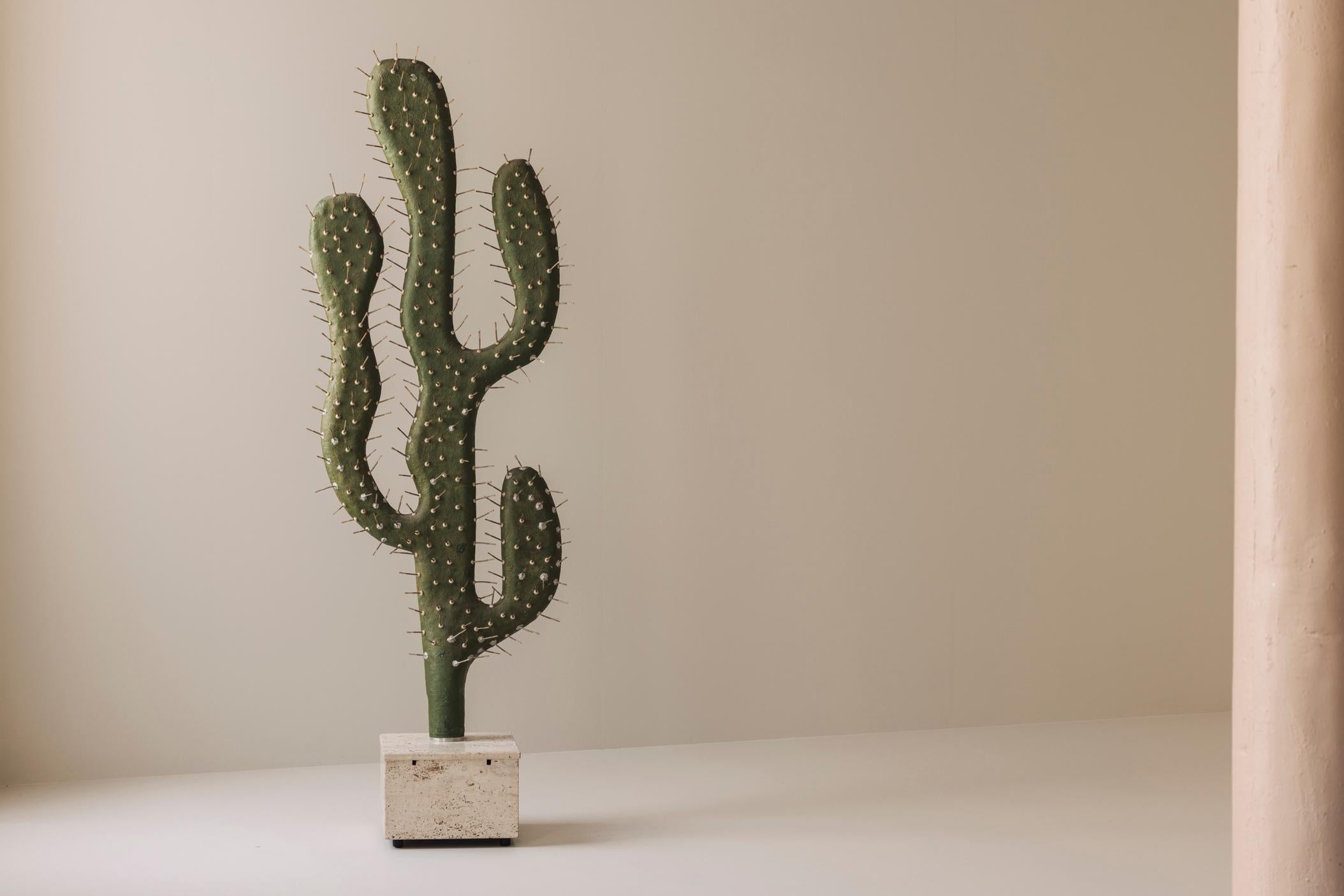 Rare et remarquable lampadaire décoratif des années 1970, ce cactus sculptural est probablement une production unique. Fabriquée en fibre de verre et montée sur un socle en travertin massif, elle séduit par sa silhouette audacieuse et ses détails