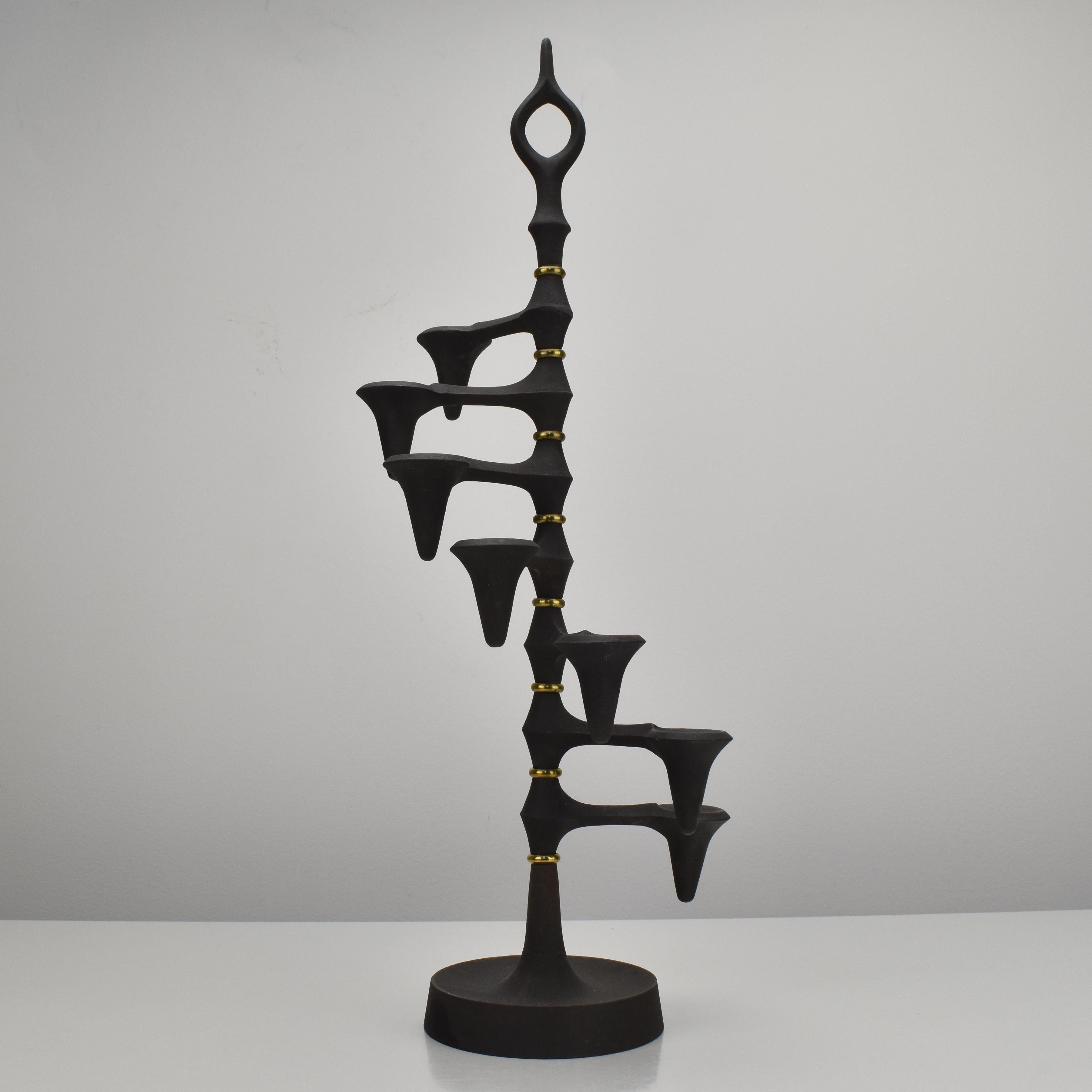 
Bring a touch of mid-century modern elegance to your home with this iconic Jens Quistgaard candelabra, designed in the 1960s.

Crafted from cast iron and brass, this sculptural piece exudes a bold and sophisticated presence. Its seven adjustable