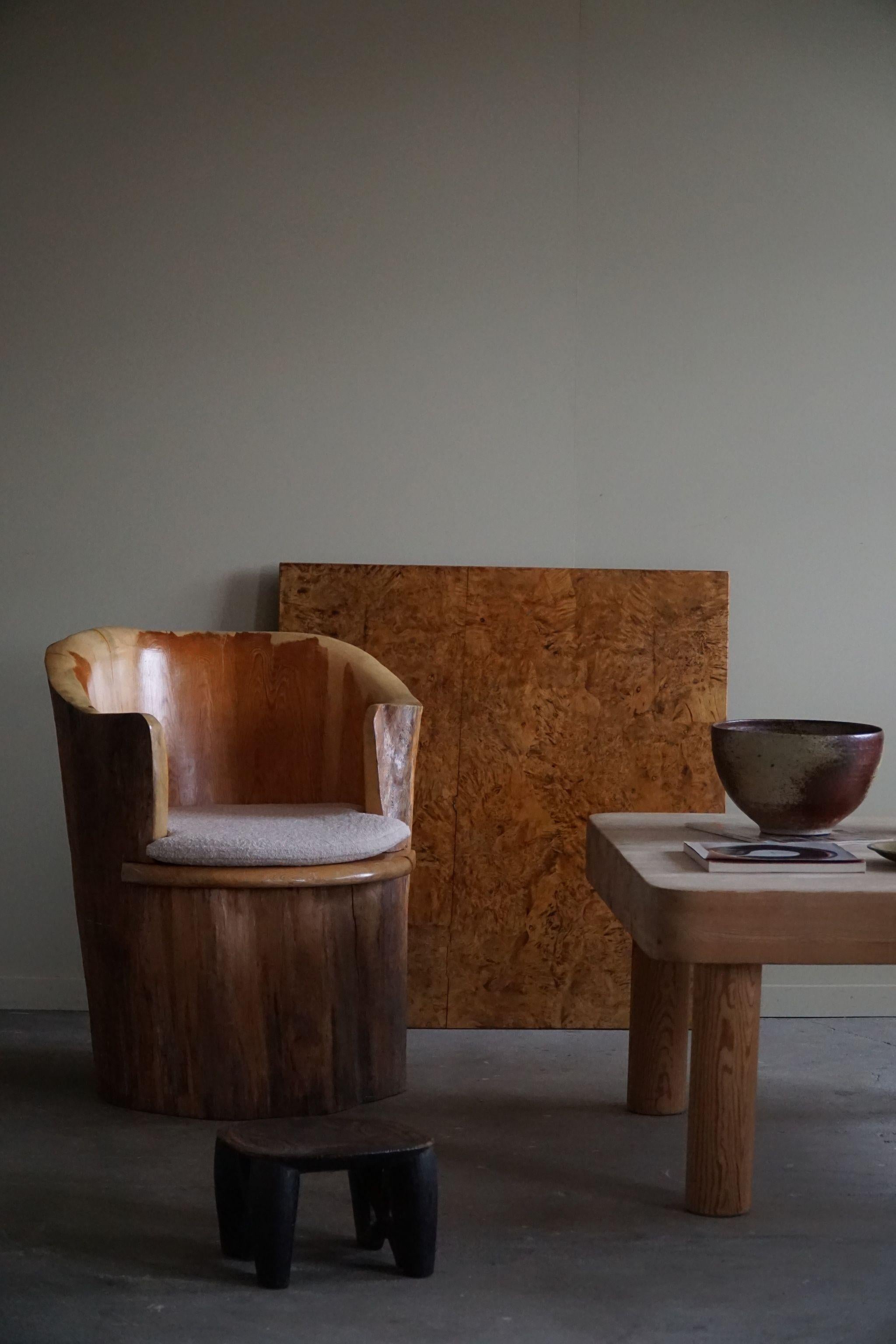 Sculptural rustic stump chair made in solid pine. Hand carved by Swedish cabinetmaker Göran Jalking. Stamped Nr. 33, okt 1968, Göran Jalking. Beautiful wood grains in this vintage piece. Seating in reupholstered bouclé, Tiree 1002 (Sand) from BUTE