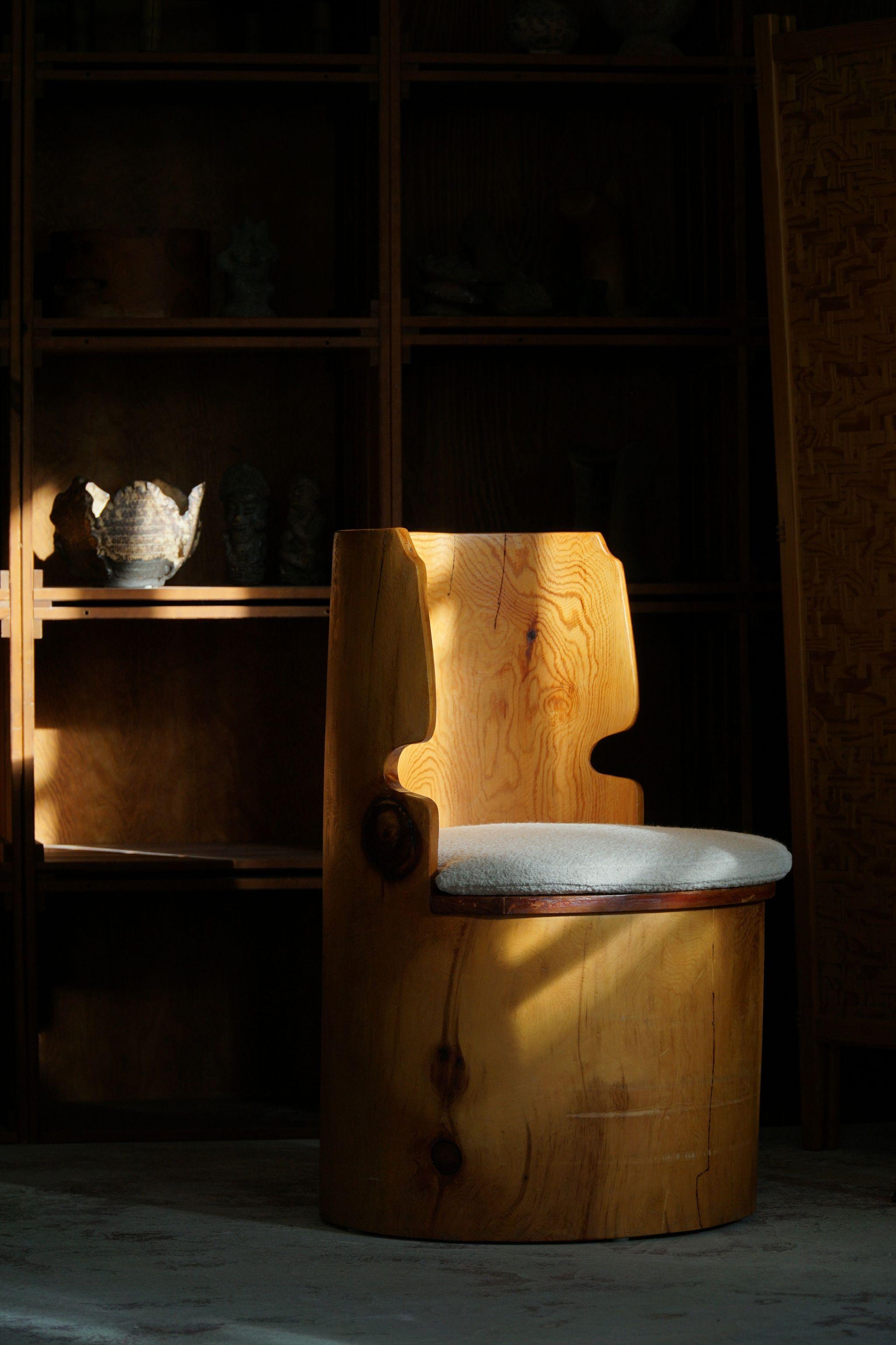 Chaise rustique sculpturale en pin massif. Sculptée à la main par un ébéniste suédois dans les années 1970. Magnifiques grains de bois dans cette pièce vintage, une pièce brutaliste vraiment authentique. Le coussin de siège en bouclette rechampi,