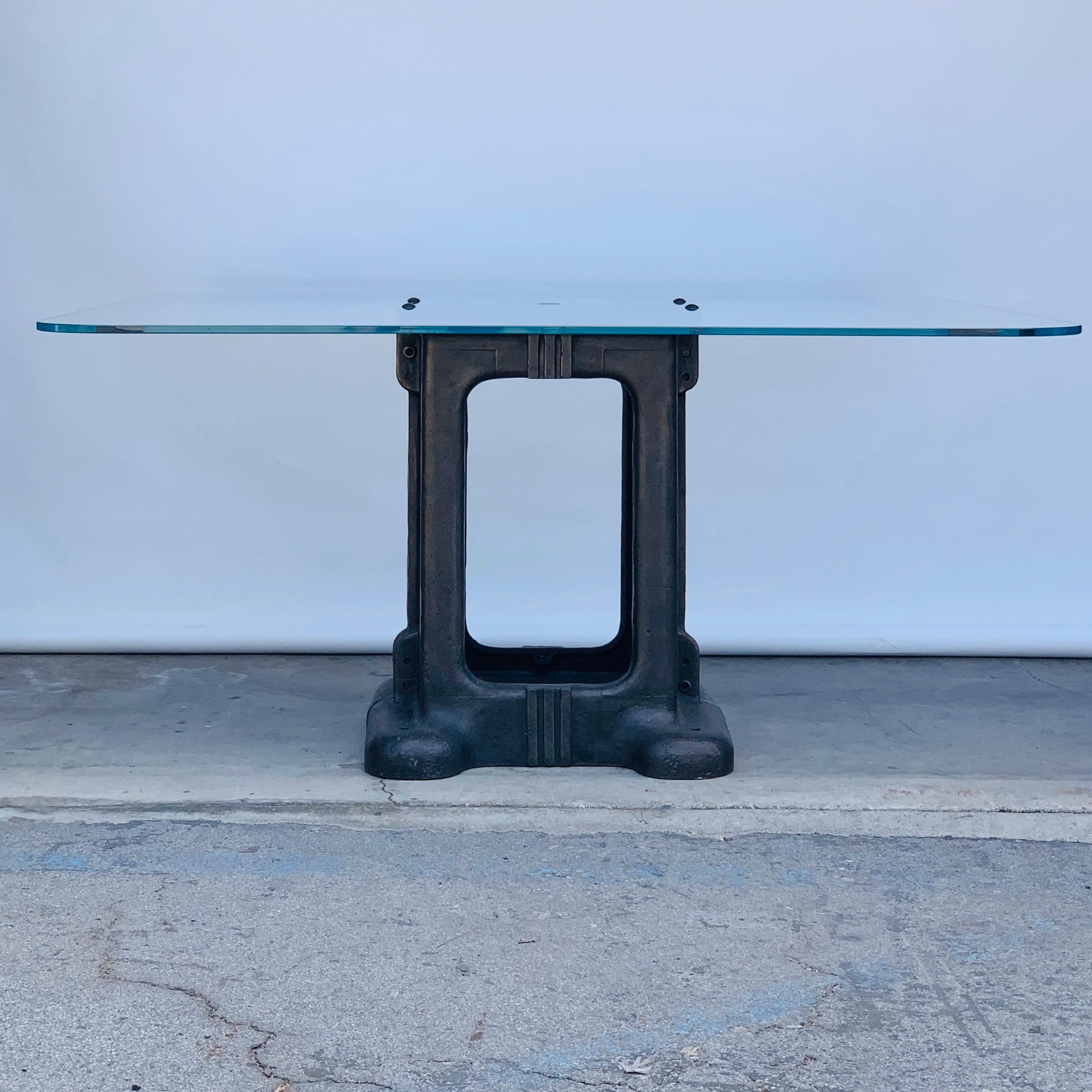 Sculptural cast iron pedestal base and glass Industrial dining / work table.

Beautiful patina on the base. Heavy custom made glass top with cable opening in the middle.

Impressive proportions comfortably seats 8-10 for dinner or allows for 4