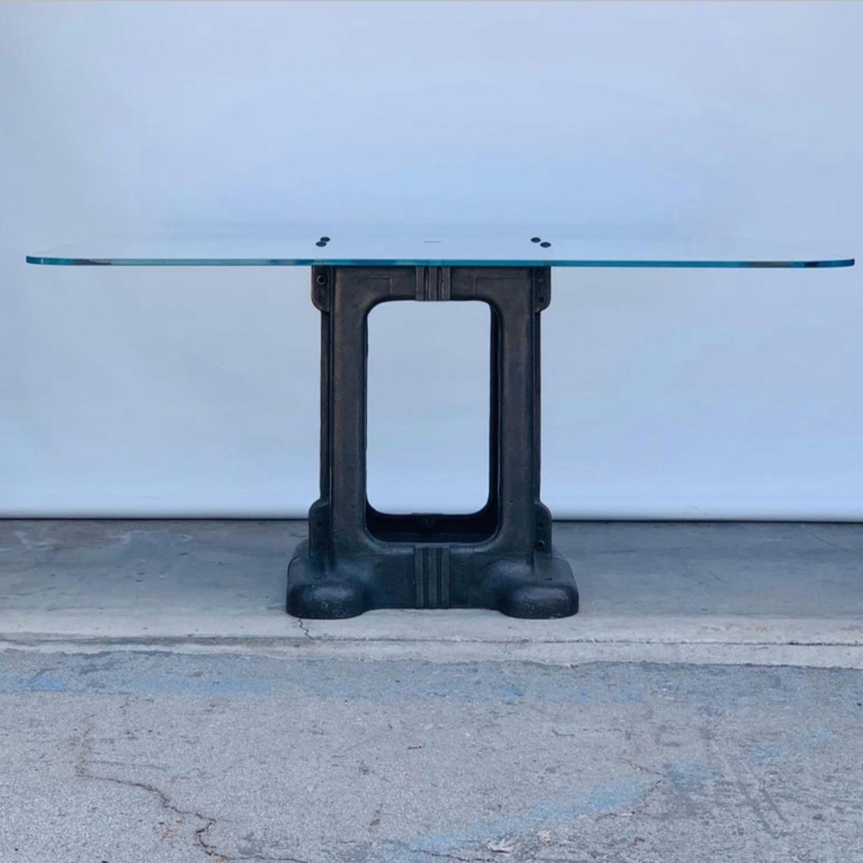 Sculptural cast iron pedestal base and glass Industrial dining / work table.

Beautiful patina on the base. Heavy custom made glass top with cable opening in the middle.

Impressive proportions comfortably seats 8-10 for dinner or allows for 4