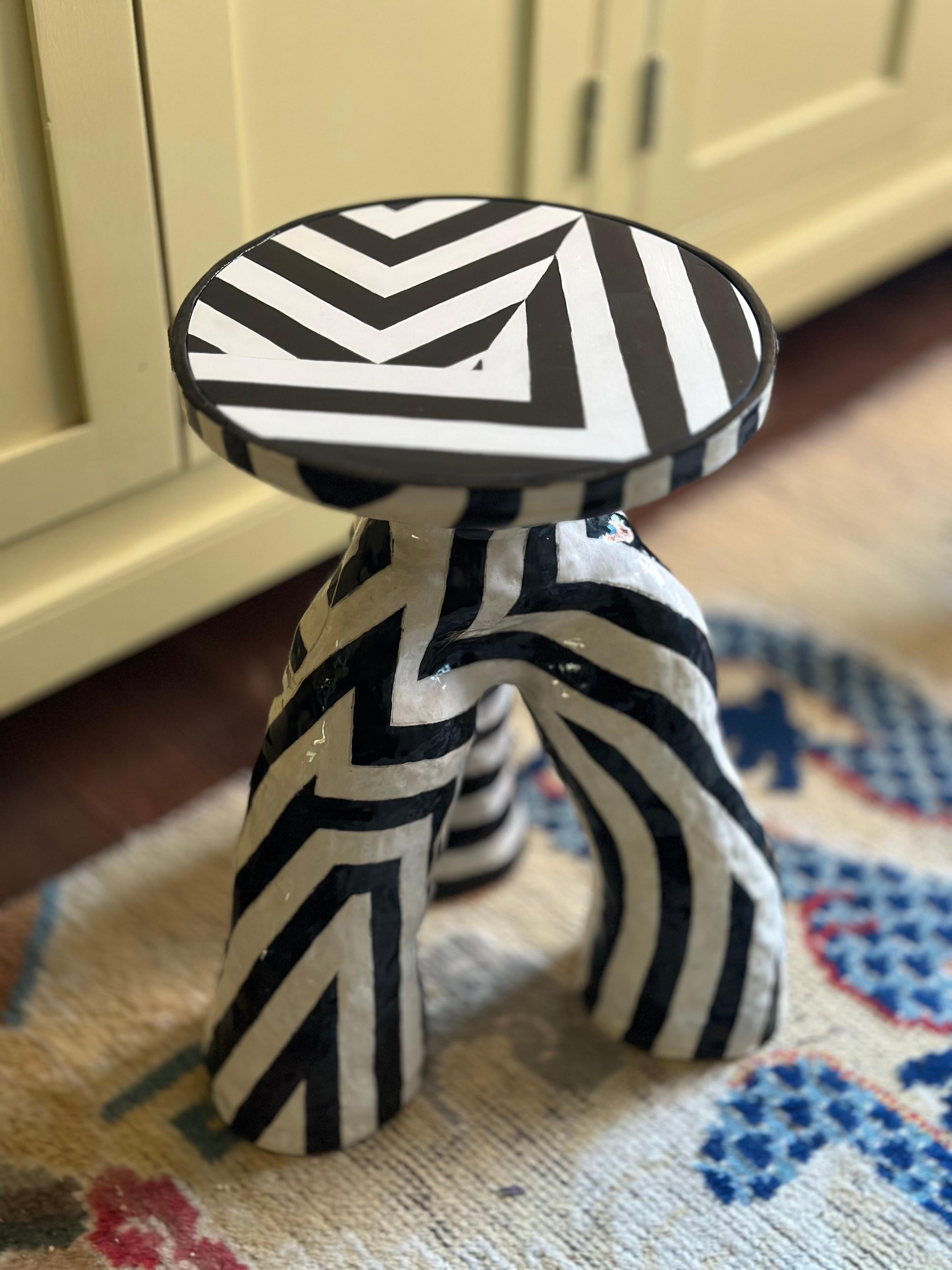 Inspirées par l'effet camouflant du motif sur une forme tridimensionnelle, ces rayures entrecroisées obscurcissent votre sens de la forme, créant un mouvement et une illusion dans la forme à triple jambe.

céramique,  plan de travail en bois peint, 