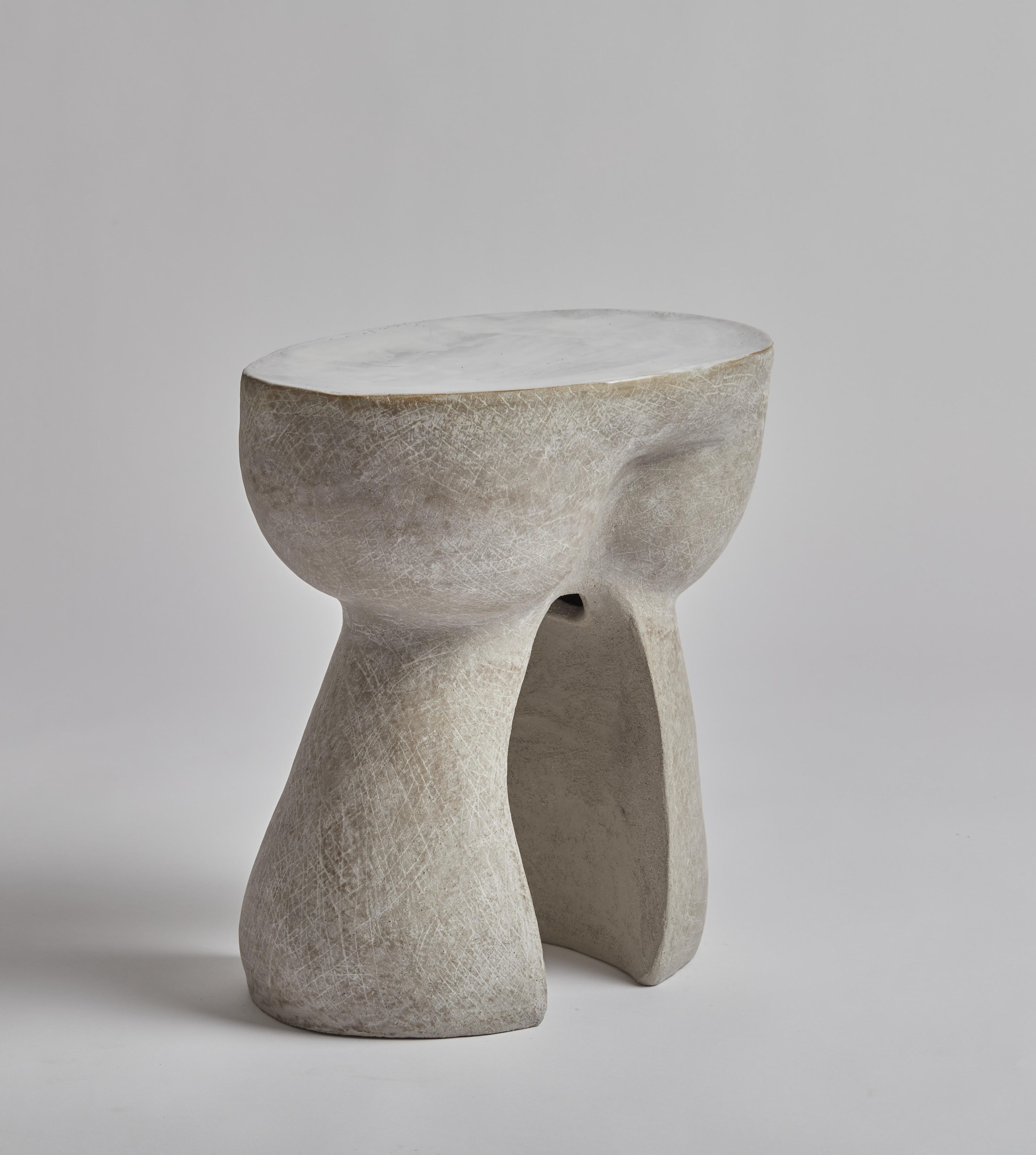 Cette table d'appoint est fabriquée à la main par le créateur à partir d'un grès gris.  Inspirée par les courbes sensuelles des sculptures de Jean Hans Ap, Kerry Hastings construit ses formes en utilisant la technique ancienne de l'enroulement avec