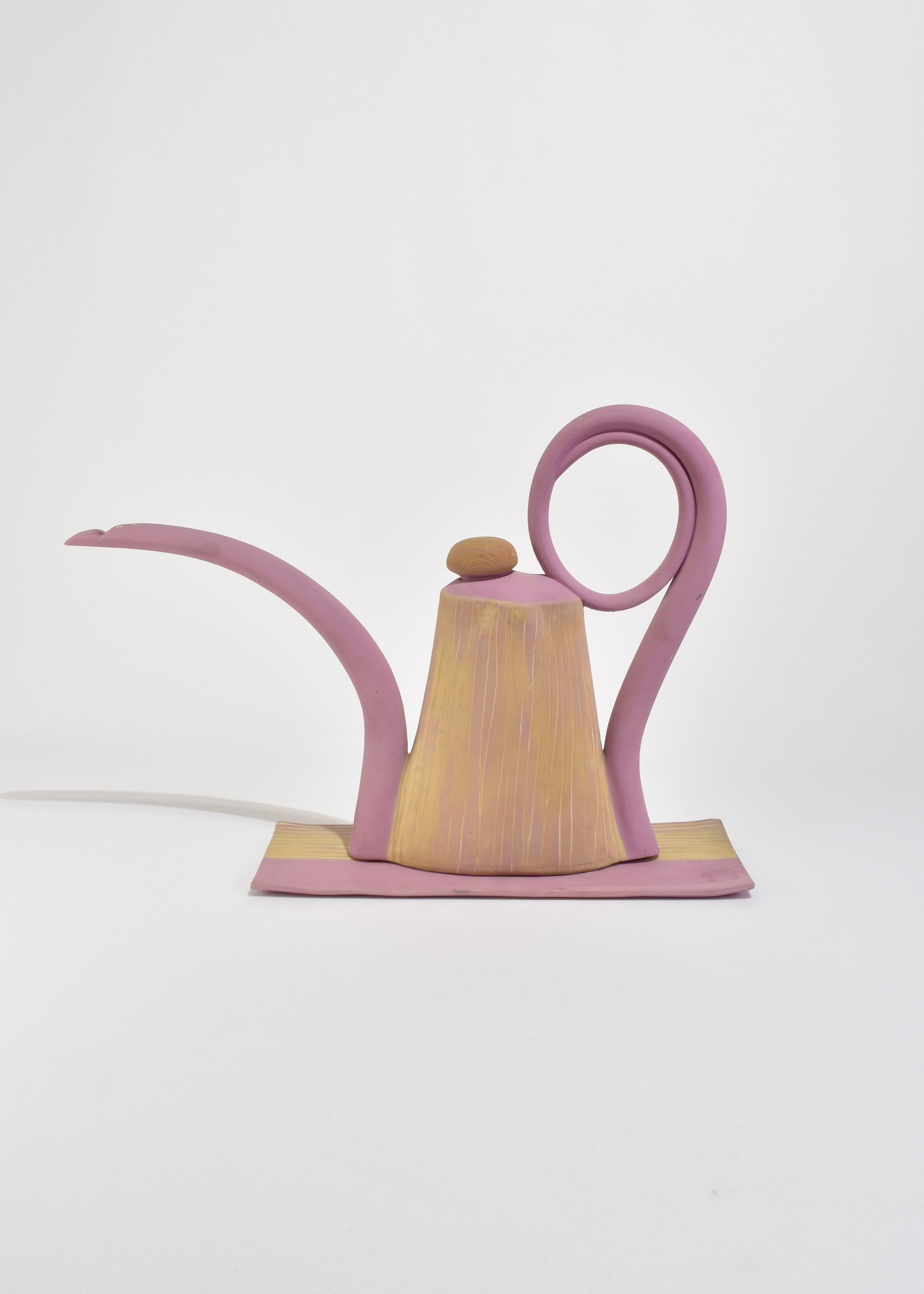Eine auffällige Keramik-Teekanne der in Frankreich geborenen und in Brooklyn lebenden Künstlerin Nadeige Choplet. Das großformatige Stück mit dem geschwungenen Ausguss und dem geschlungenen Griff ist in matten Mauve- und zarten Gelbtönen gehalten.