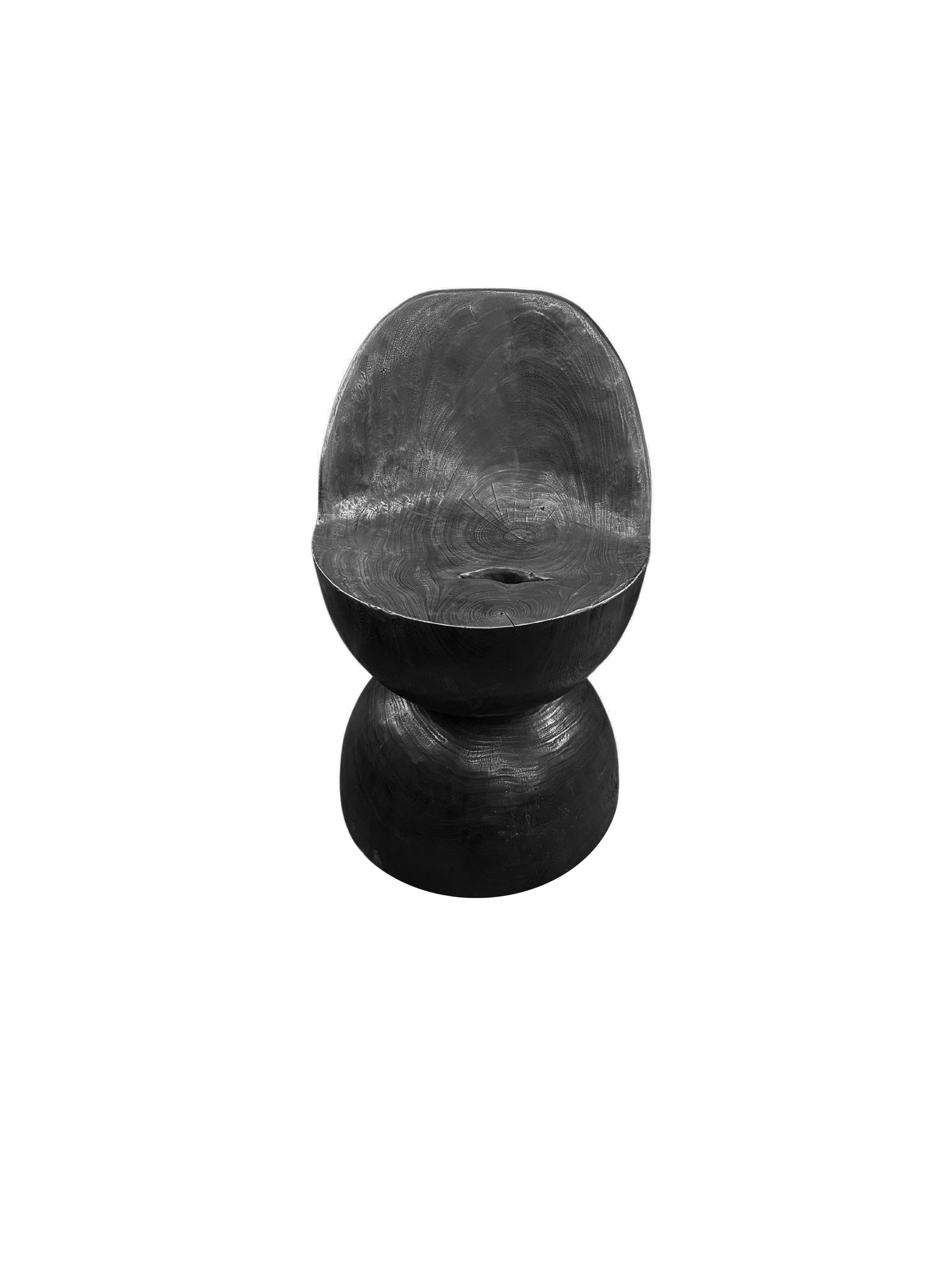 Une chaise merveilleusement sculpturale avec un mélange de textures et de nuances de bois. Sculpture unique et pièce polyvalente, cette chaise a été fabriquée à partir d'un seul bloc de bois de suar. Méticuleusement sculpté pour obtenir une forme