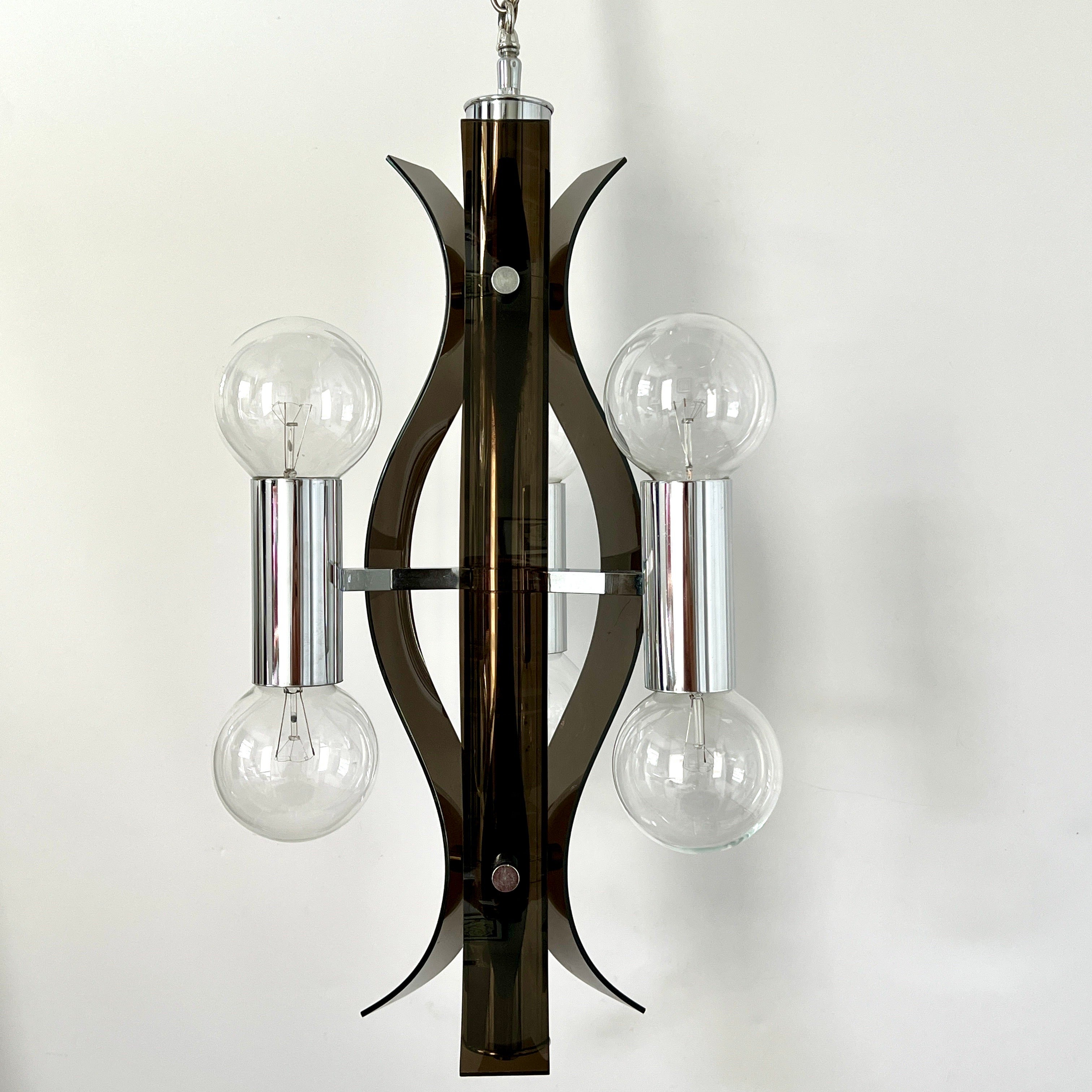 Mid-century modern sculptural chandelier in chrome and smoked lucite attributed to Robert Sonneman. Fixture has three sided design and features dark gray lucite scrolls with chrome cylinders and stud accents.  Fitted with six lights, three uplights