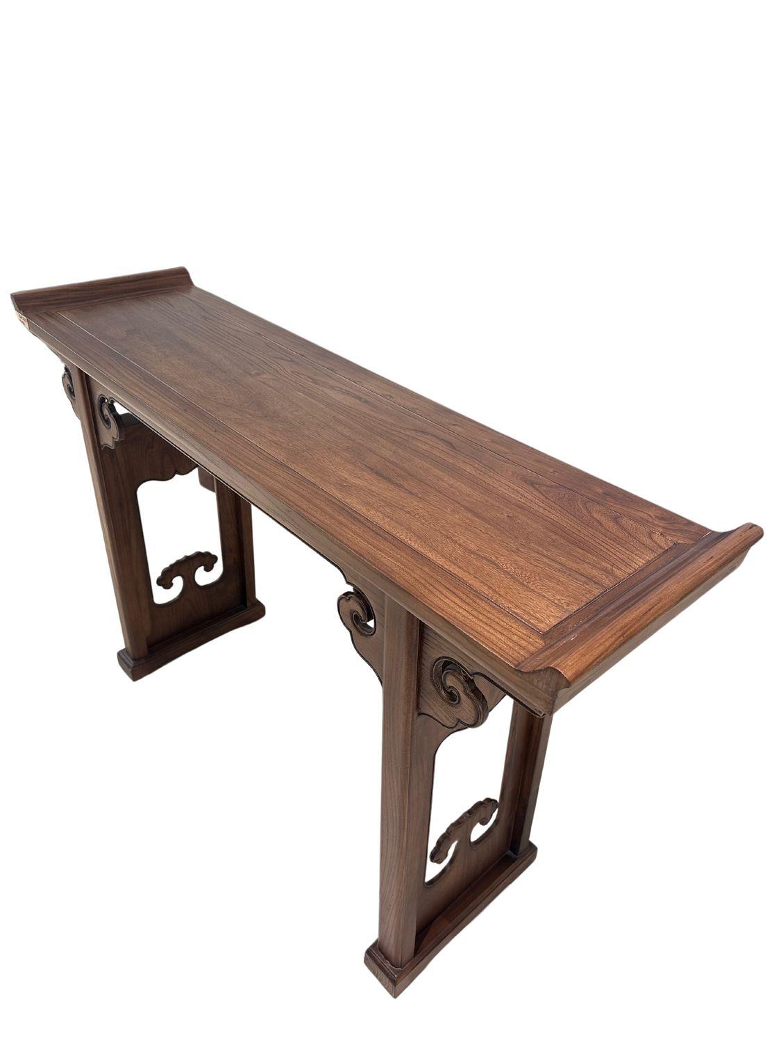 Handcrafted from premium elm wood, this piece captures the essence of classic Chinese design inspired by Qing dynasty style with intricate carvings and smooth, natural finishes. The table’s ornate leg scrollwork and raised tabletop edges speak to a