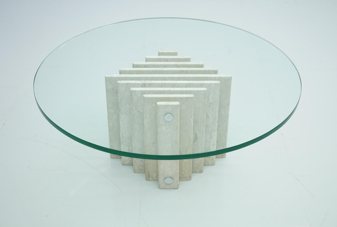 Sculptural circular travertine coffee table with a glass top, 1970.