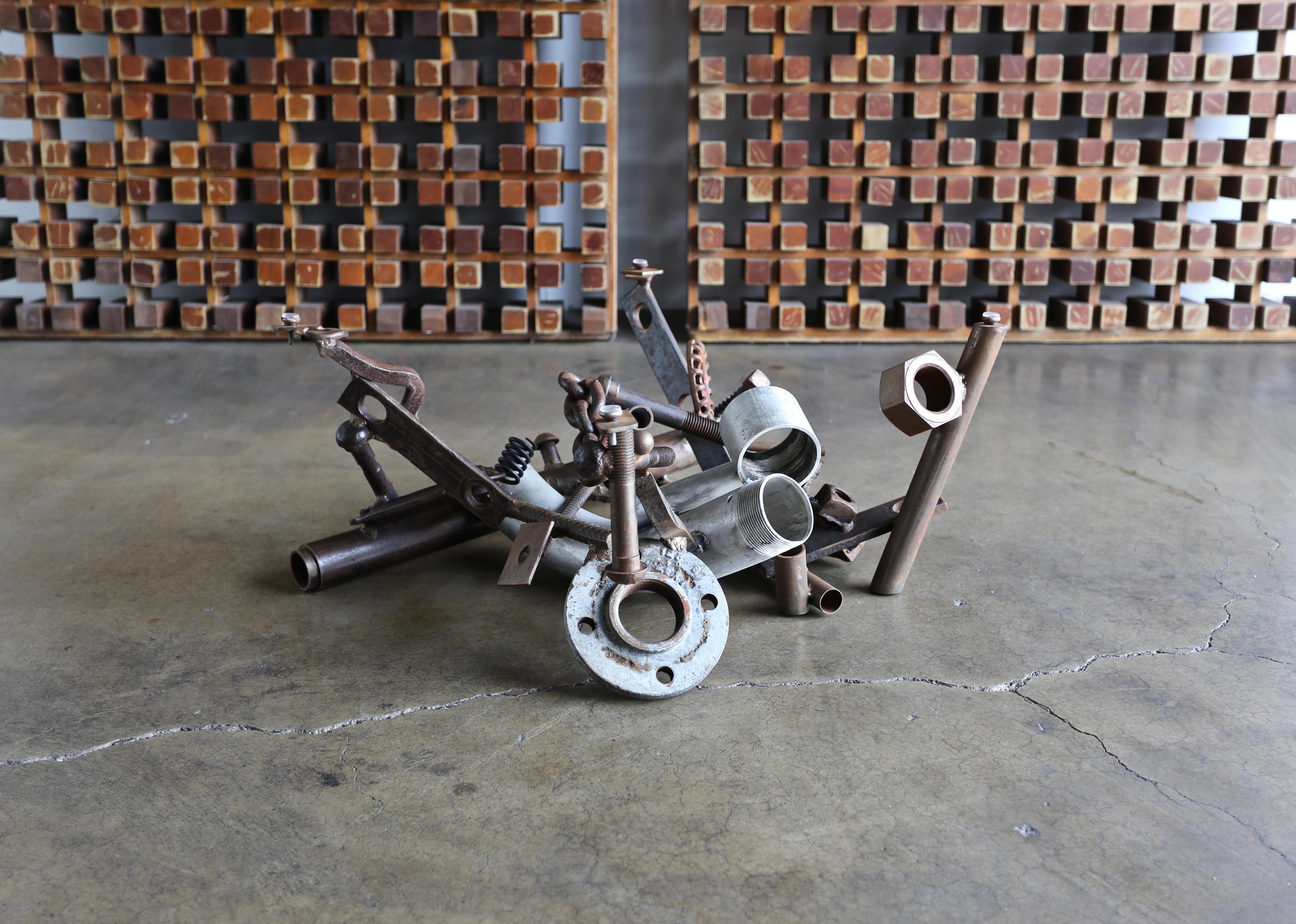 Sculptural welded assemblage coffee table by Bruce Gray, 1990s. This piece is signed. 

This coffee table measures: 47.75