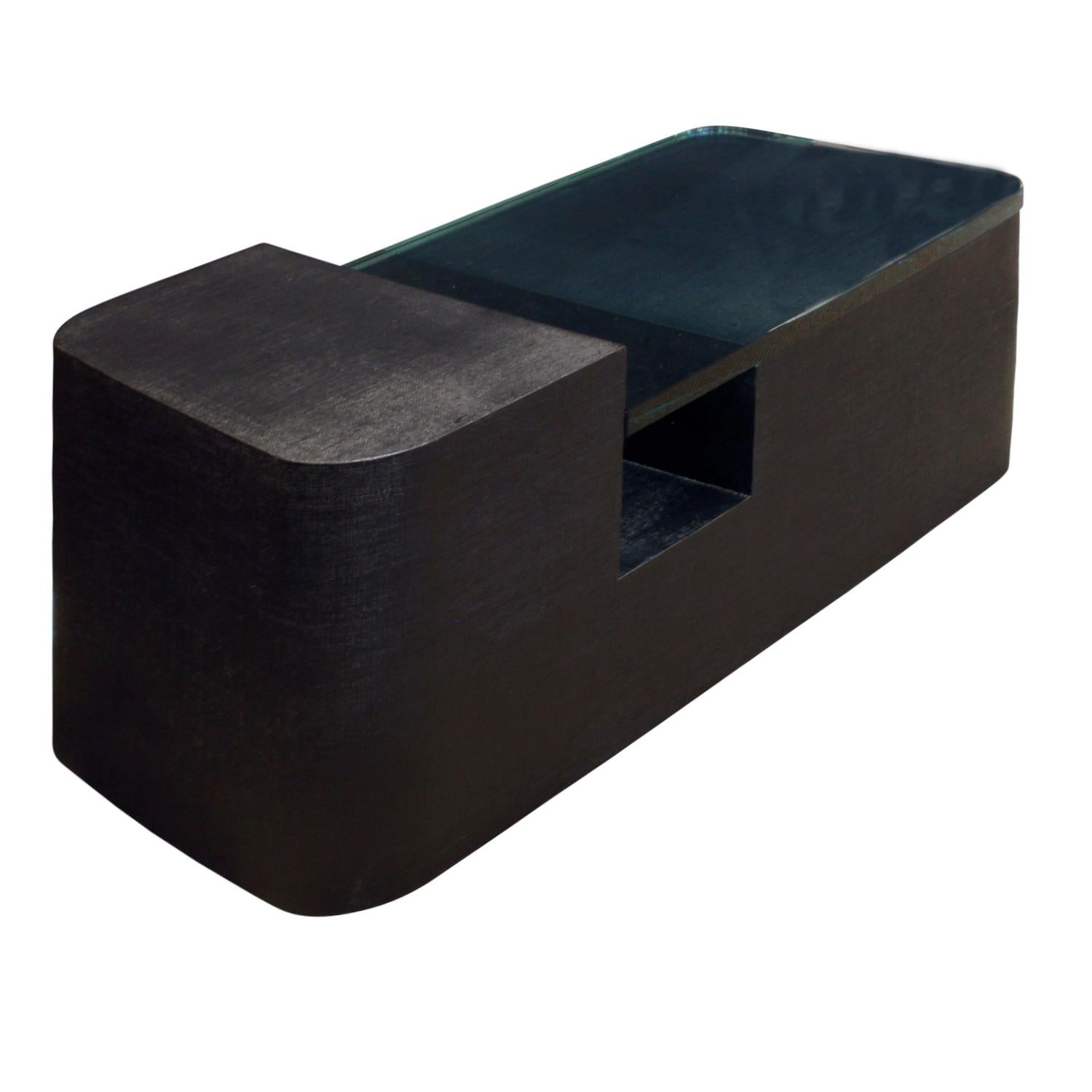 Sculptural coffee table in black lacquered linen with thick fitted glass top, American, 1970s.