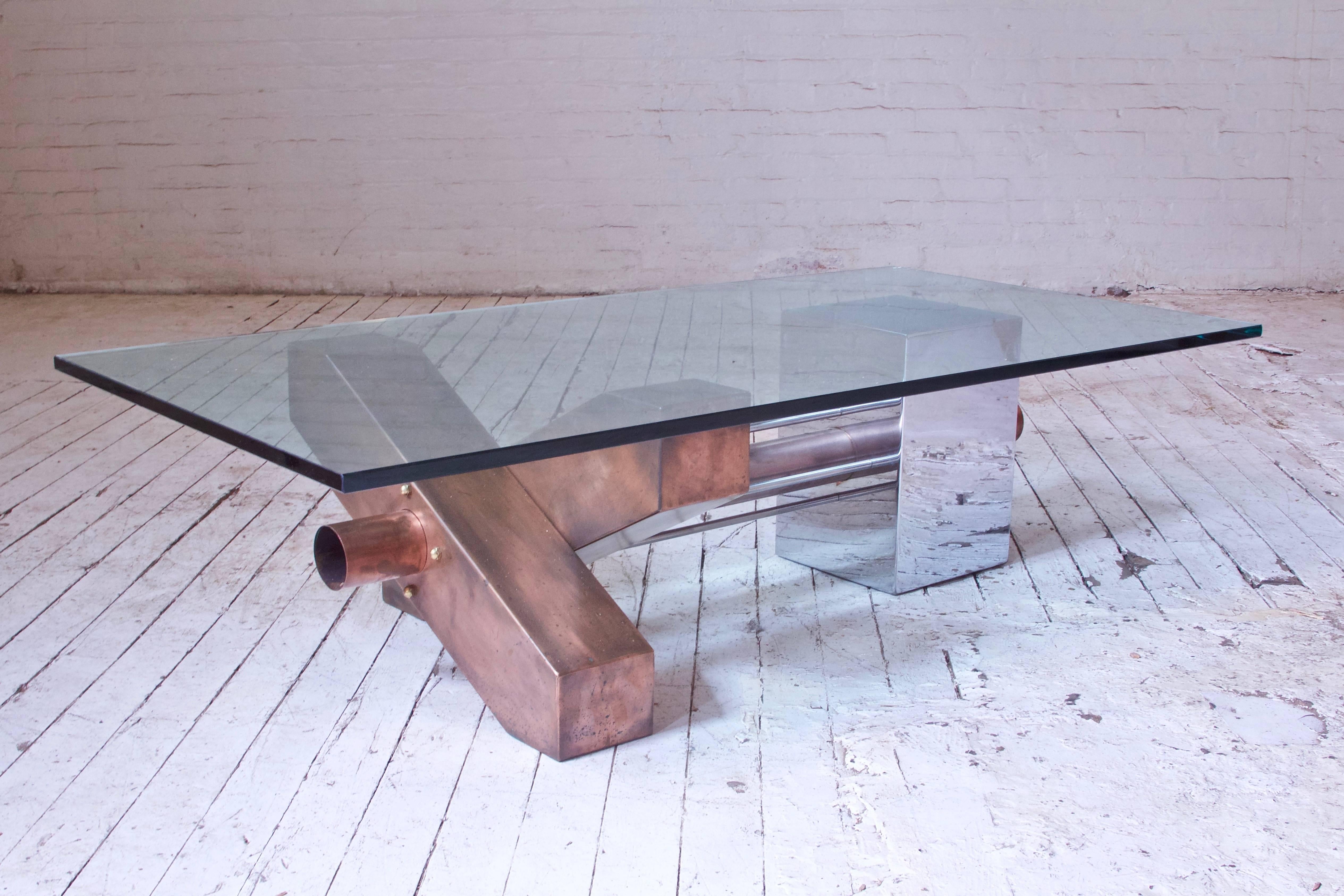 Unique and well made coffee table with robust proportions and lovely patination to mixed metals throughout. Quality glass top with bevelled edges, great detail with chrome and brass bolt accents and stainless steel stretchers. Very good vintage