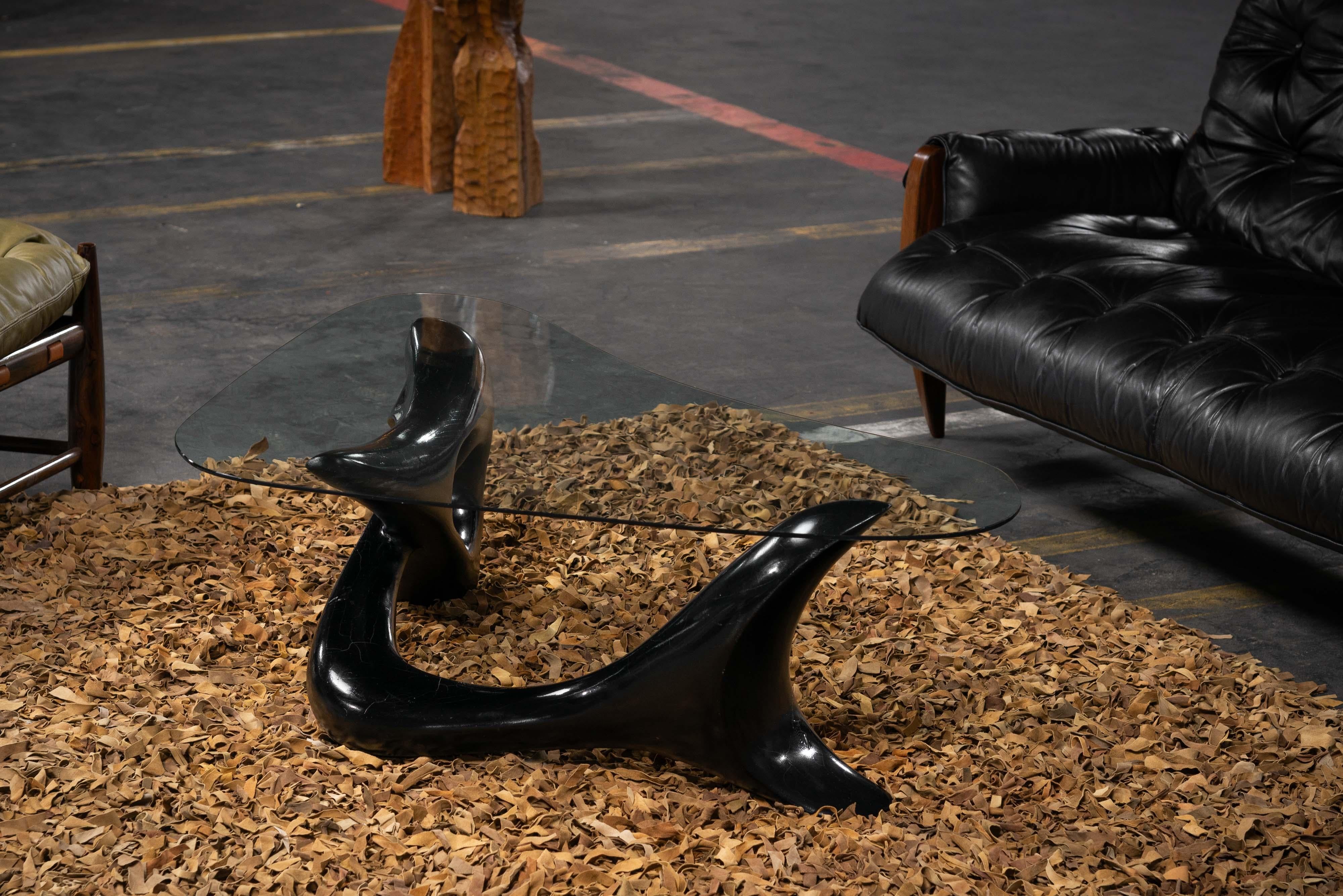 Sculptural coffee table by an unknown artist made in France in 1966. It's got a unique shape, kind of like a mermaid, fish, dolphin, or organic being. It is made of black-painted beech wood. On top, there's the original and pretty organic-shaped