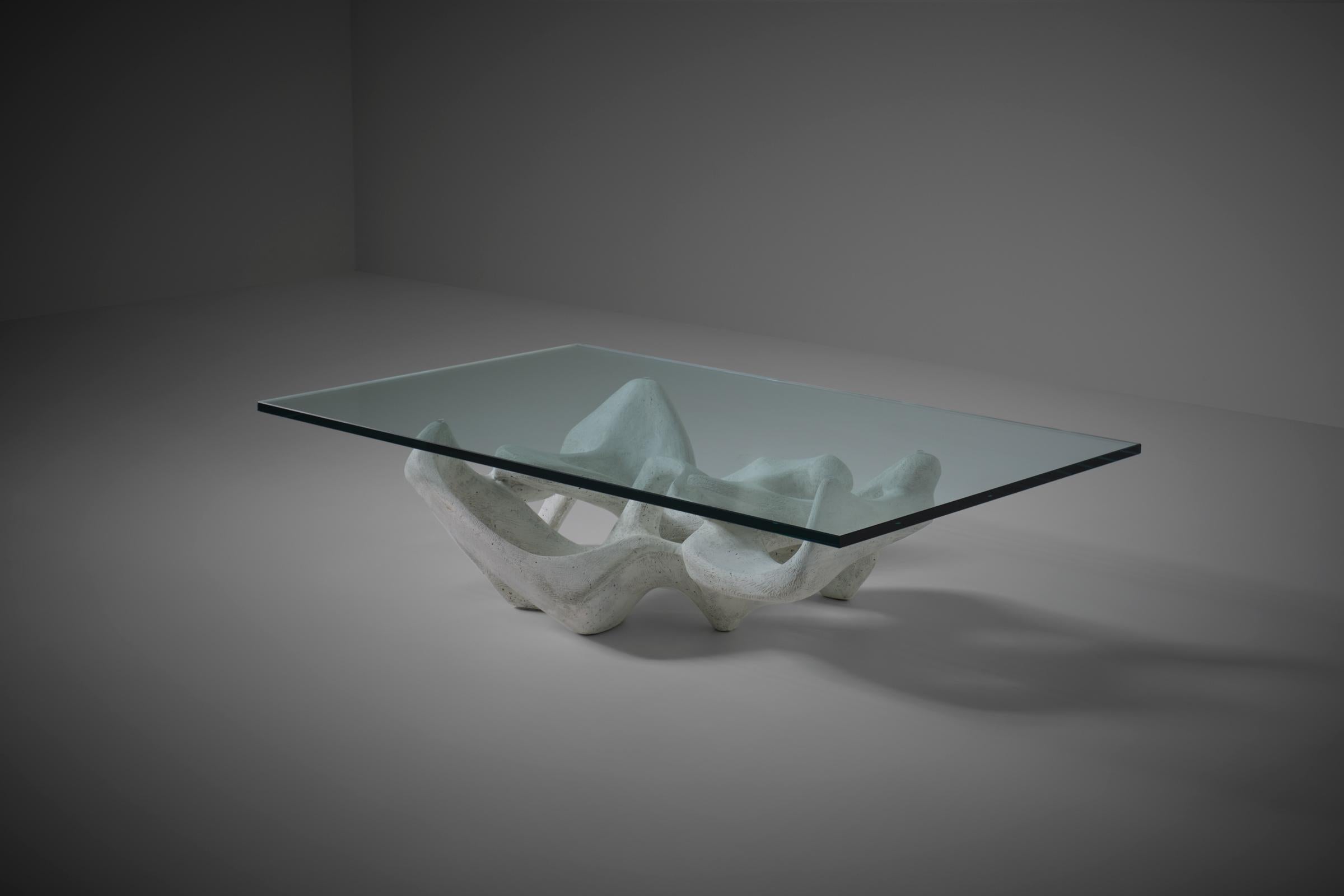 Sculptural concrete coffee table, Italy 1970s. Beautiful organic shapes that flow into each other. Sculpted out of strong solid concrete with a nice structured bone white mineral finish. The table is beautiful from every angle. In very good